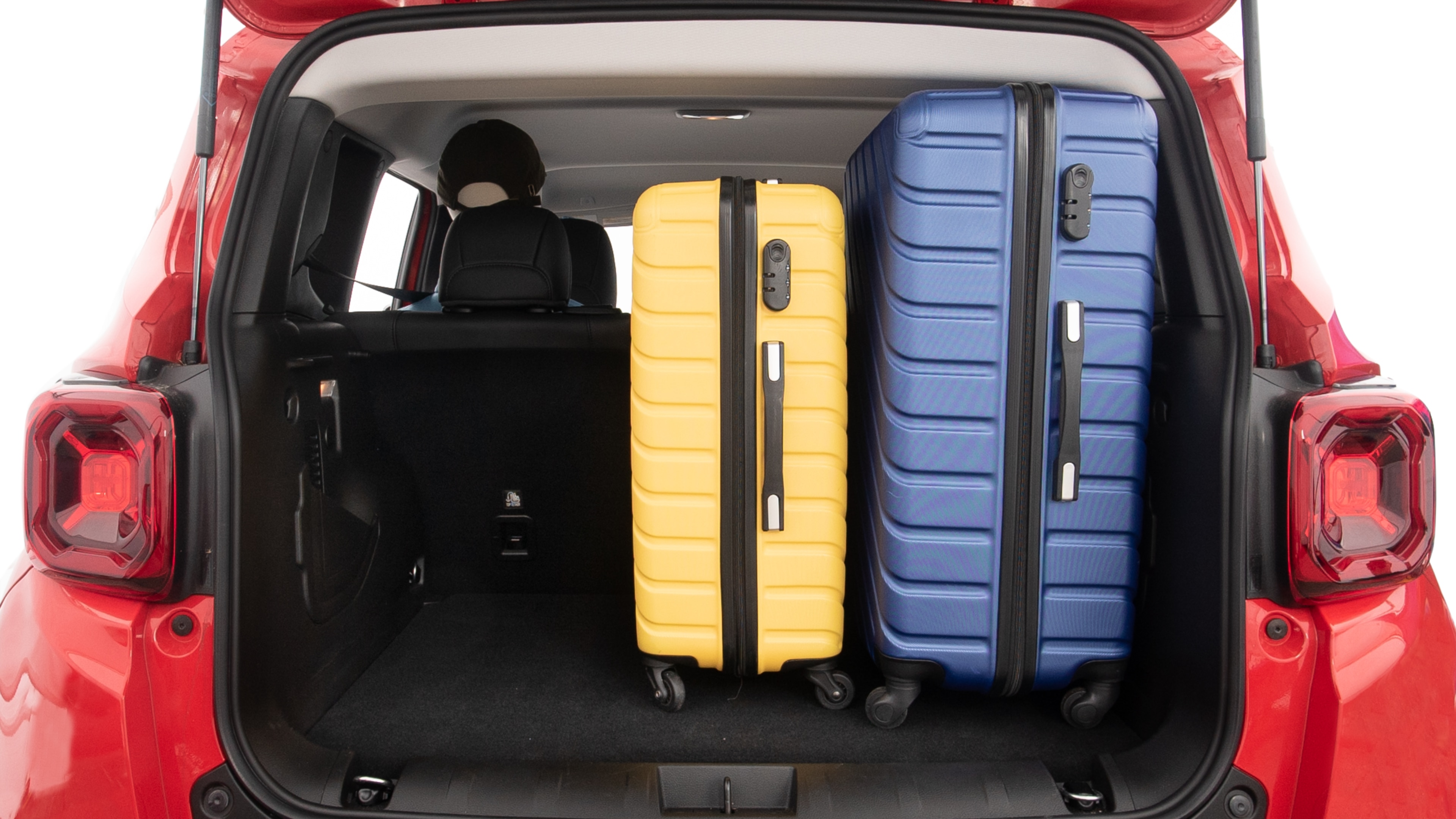 The trunk lid is open, showing full view of the trunk space. One extra large and two large suitcases are placed inside.