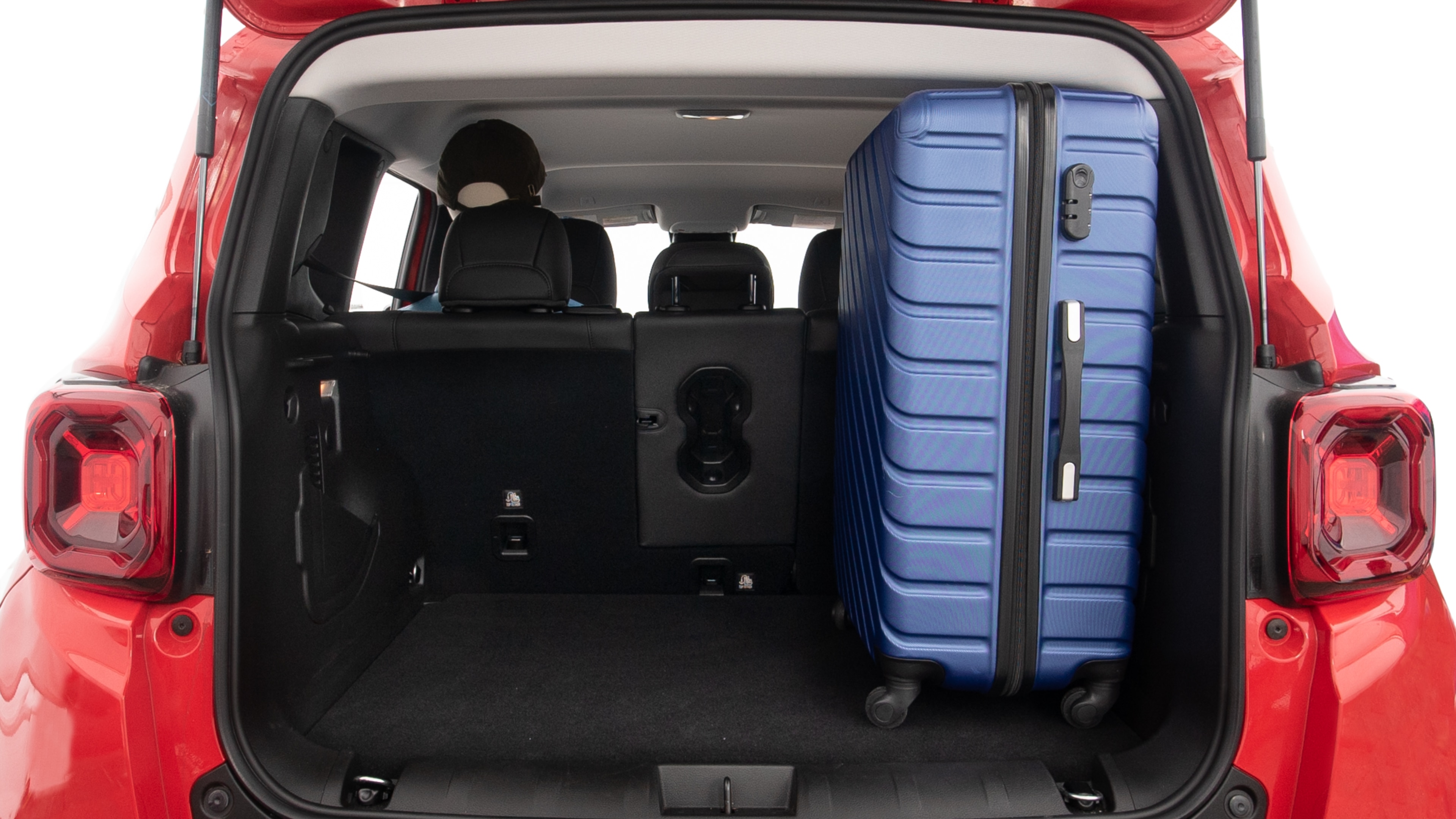 The trunk lid is open, showing full view of the trunk space. One extra large and two large suitcases are placed inside.