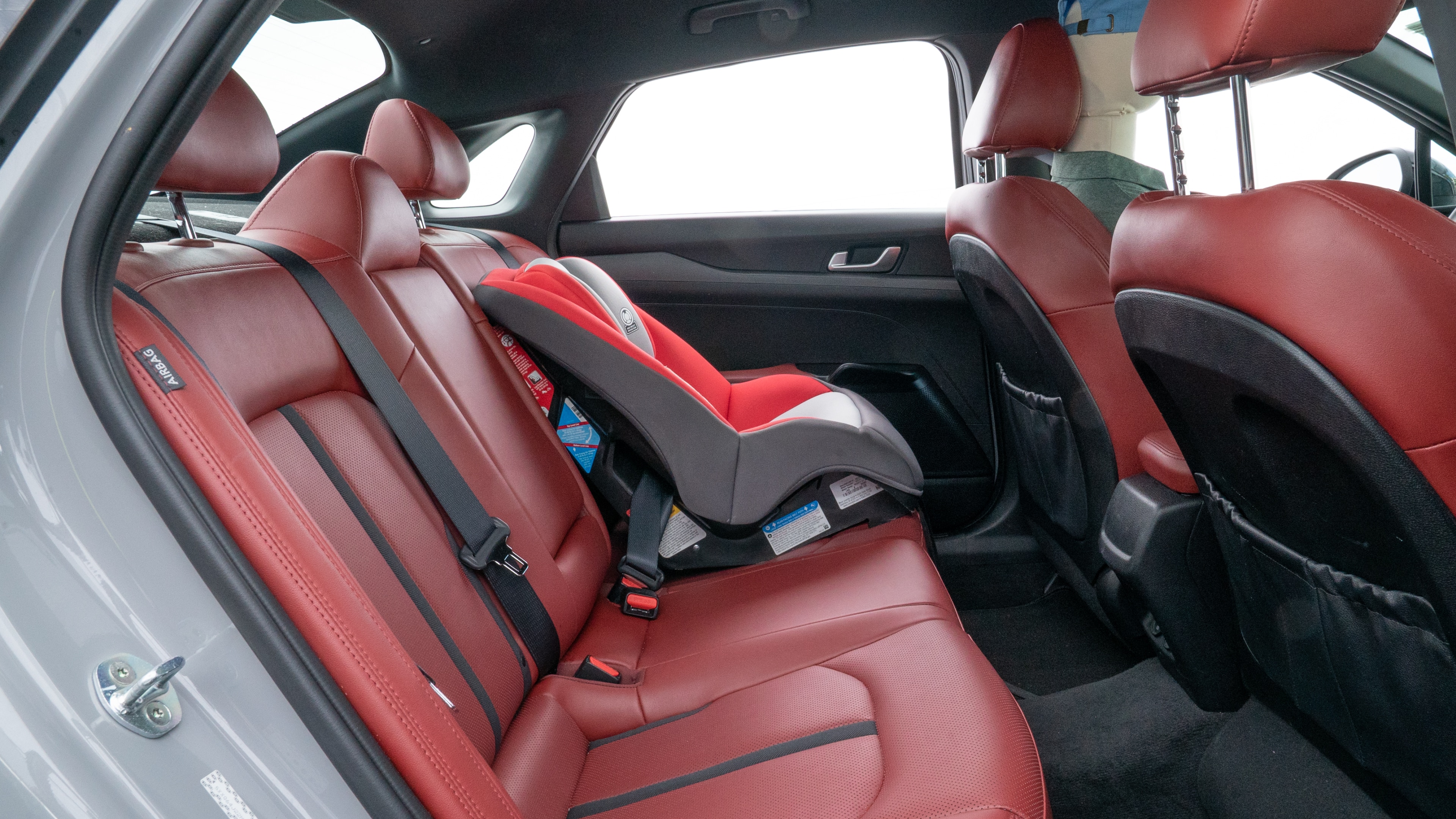 A series of second-row backseat photos is shown including one seating a baby seat and one seating a 6'1" mannequin.
