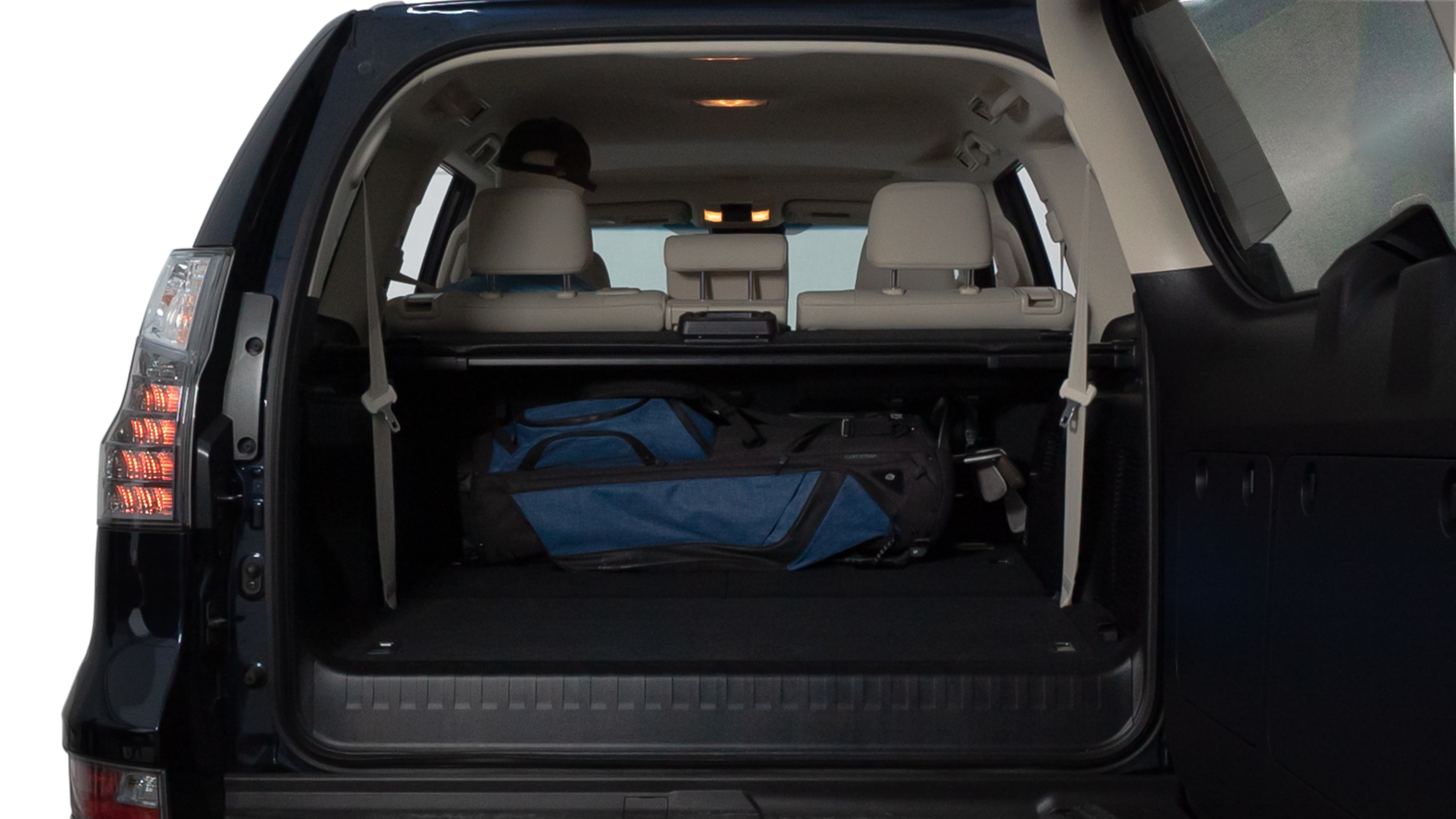 The trunk lid is open showing full view of the trunk. A baby stroller, three grocery carriers, two camping chairs in the carrying bag, and a set of golf clubs are placed inside.