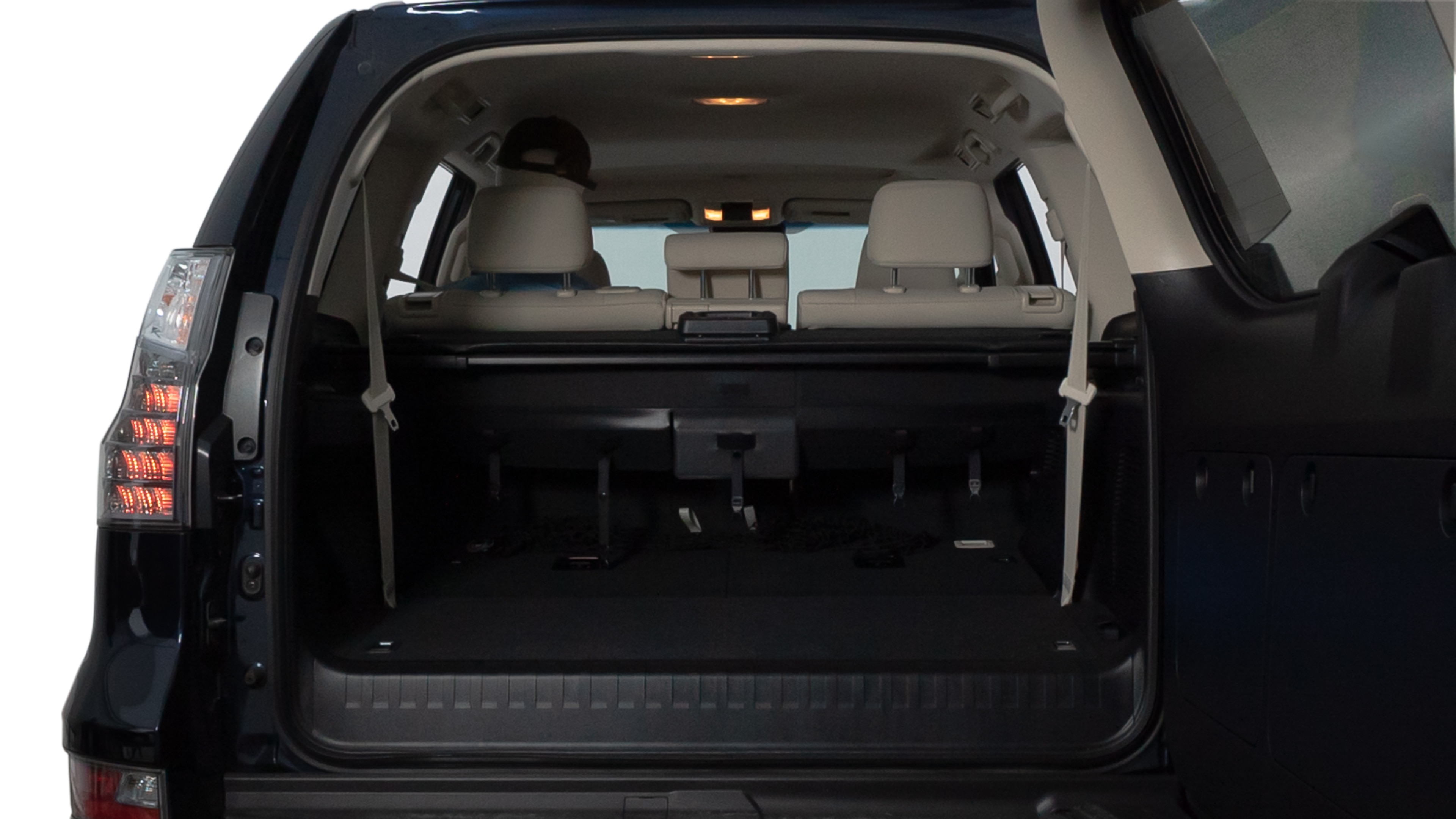The trunk lid is open, showing full view of the trunk space. Two medium and two small suitcases are placed inside.