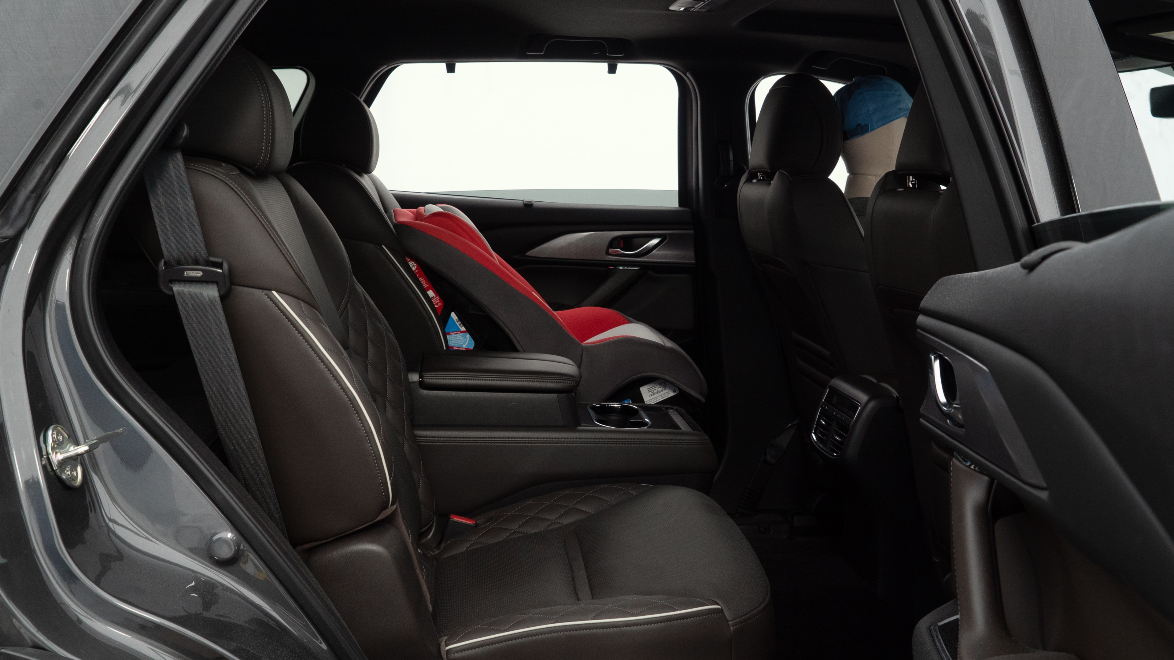 A series of second-row backseat photos is shown including one seating a baby seat and one seating a 6'1" mannequin.