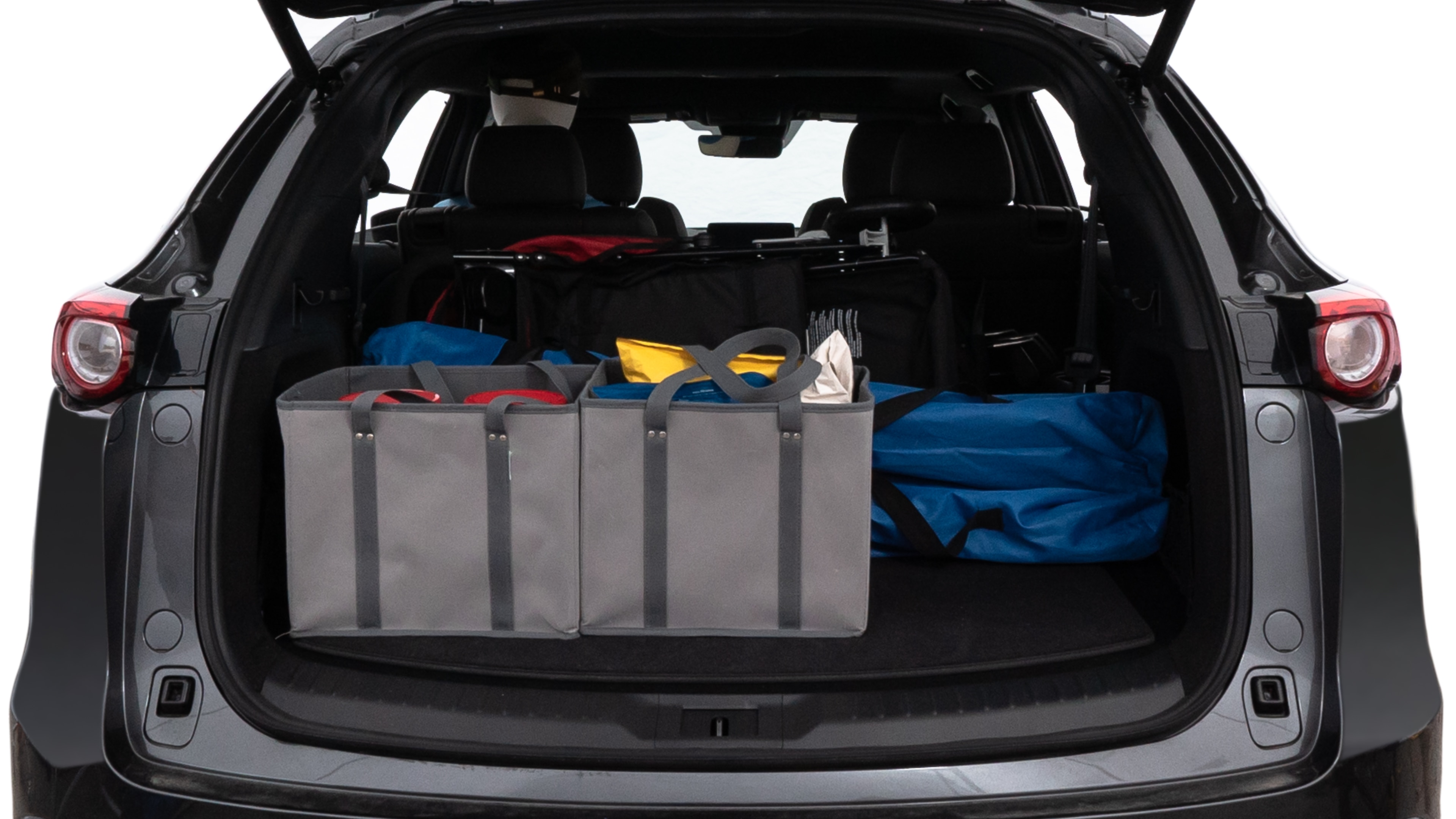 The trunk lid is open showing full view of the trunk. A baby stroller, three grocery carriers, two camping chairs in the carrying bag, and a set of golf clubs are placed inside.
