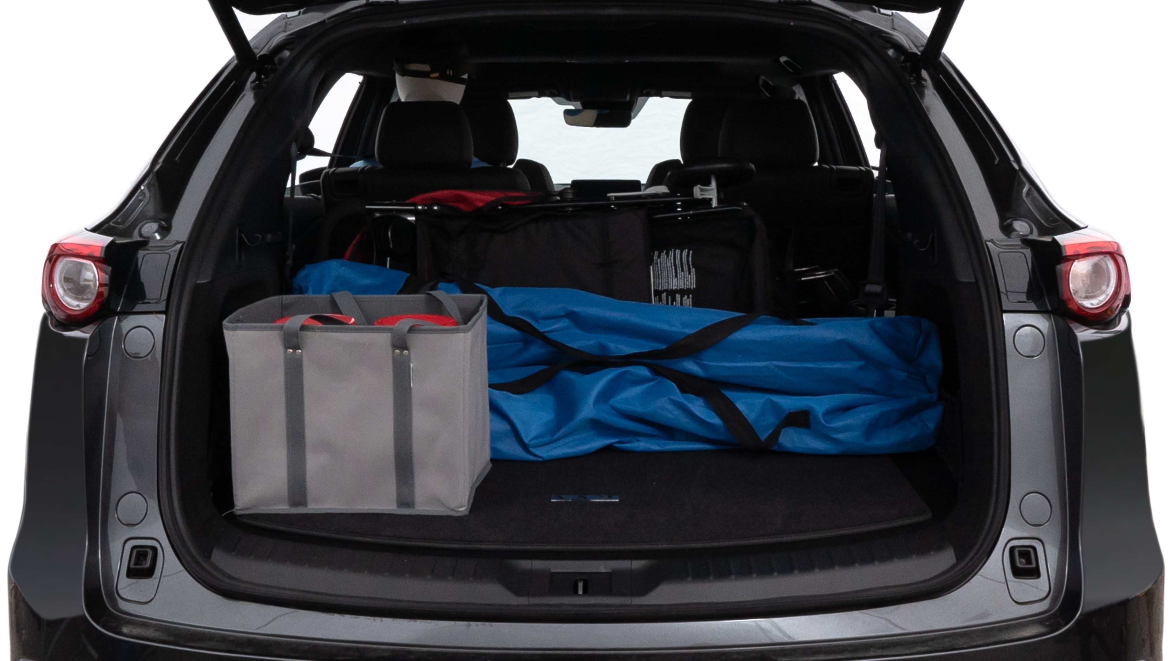 The trunk lid is open showing full view of the trunk. A baby stroller, three grocery carriers, two camping chairs in the carrying bag, and a set of golf clubs are placed inside.
