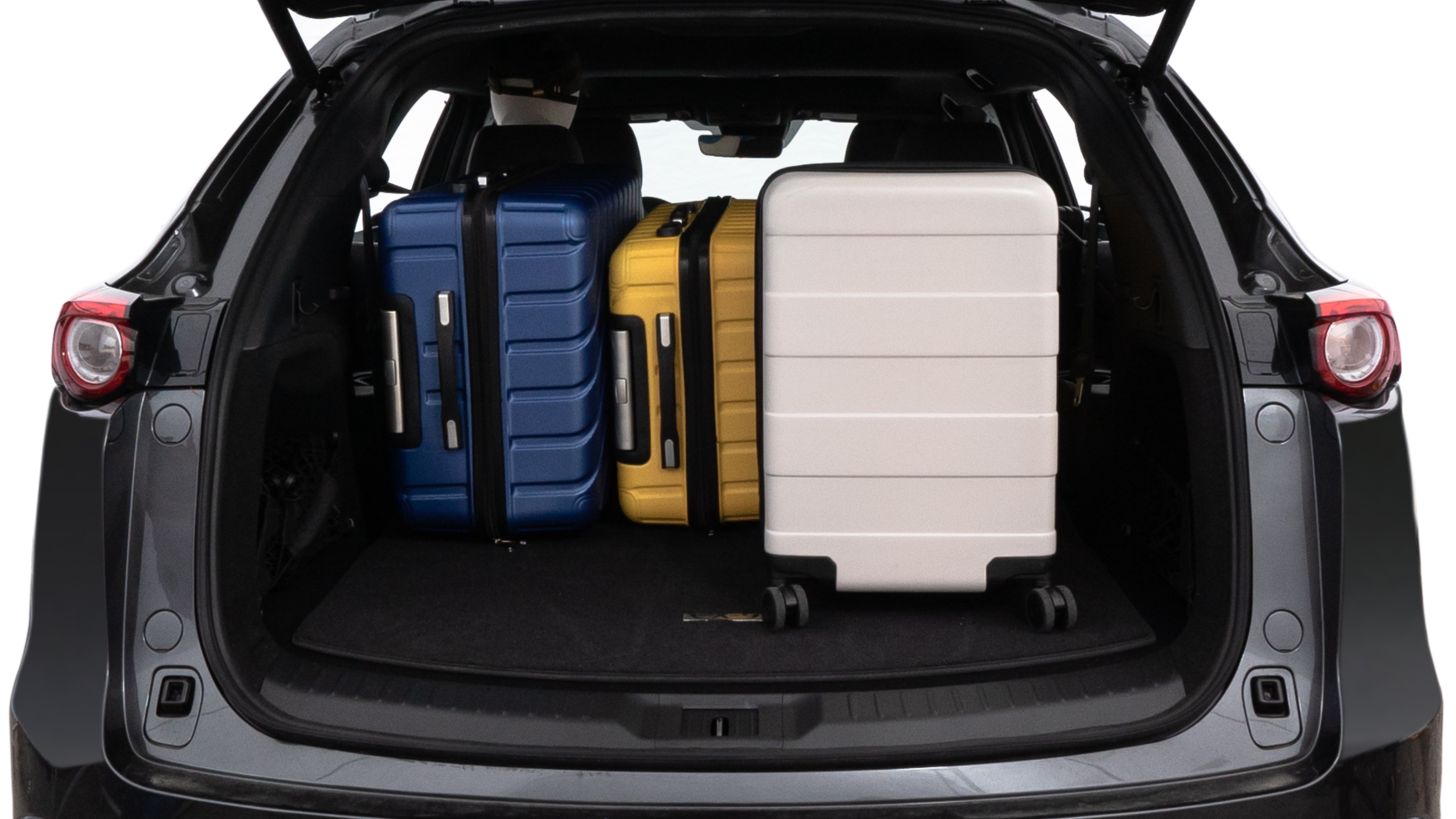 The trunk lid is open, showing full view of the trunk space. One large, two medium, and two small suitcases are placed inside.