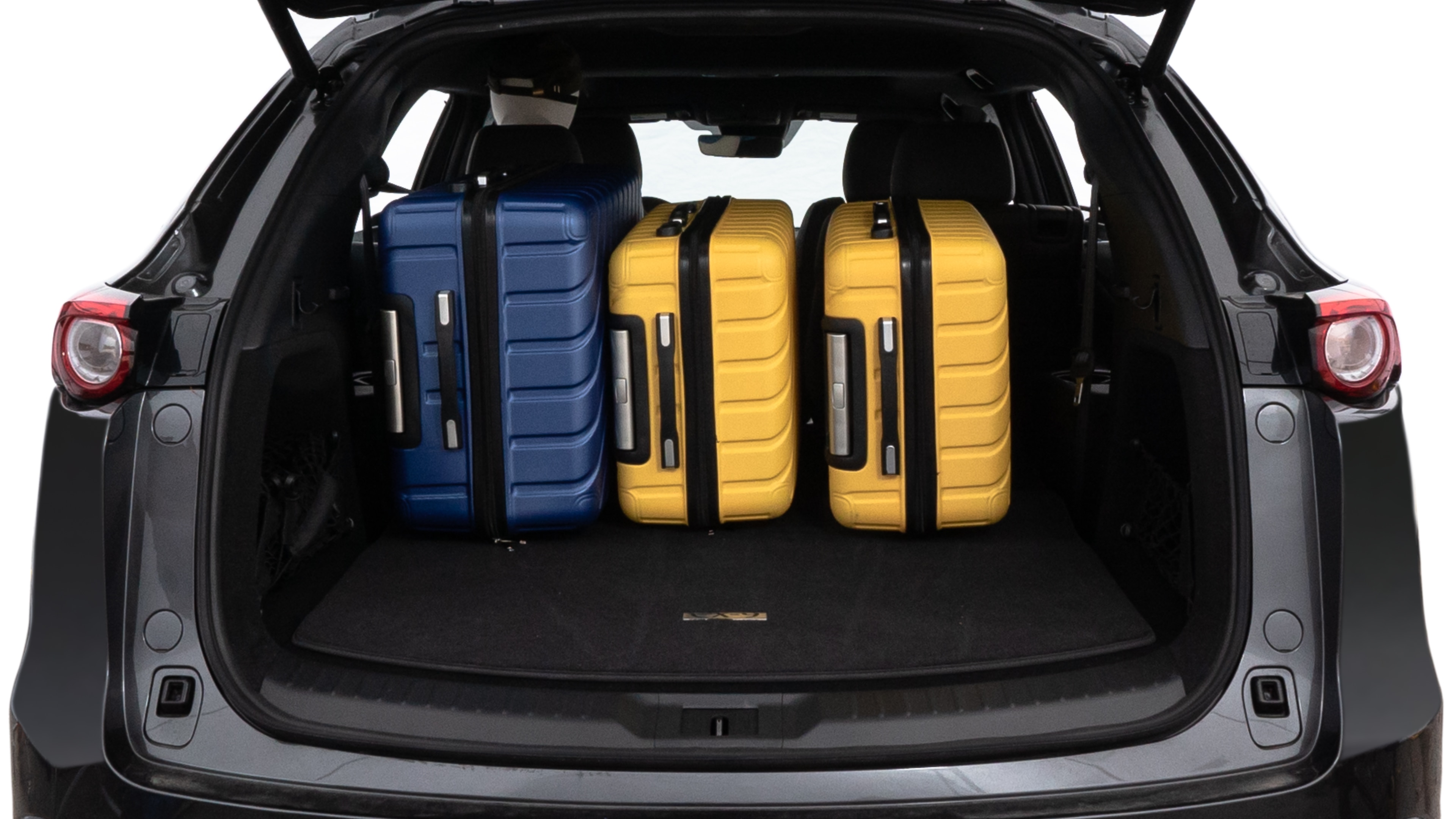 The trunk lid is open, showing full view of the trunk space. One large, two medium, and two small suitcases are placed inside.