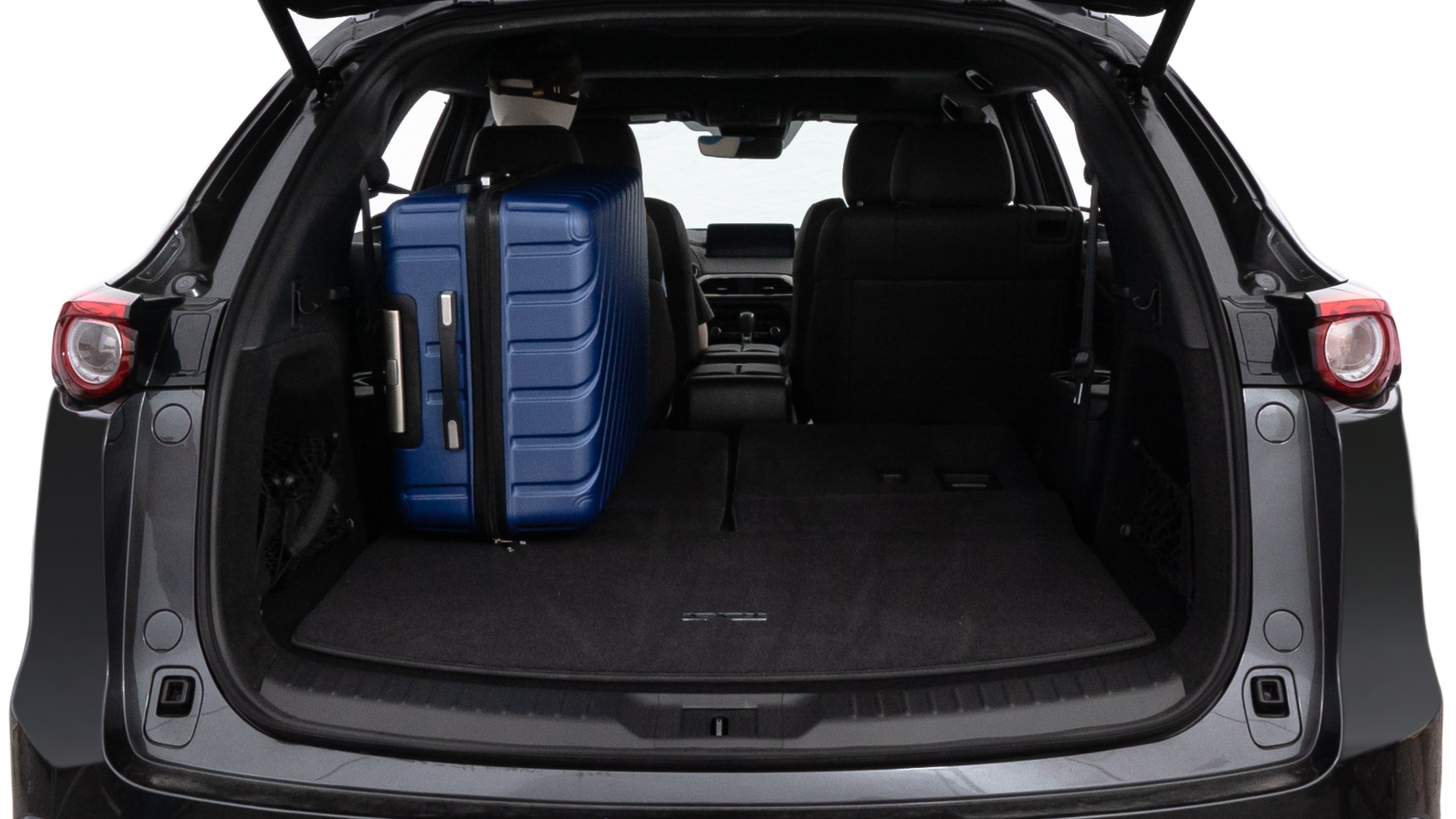 The trunk lid is open, showing full view of the trunk space. One large, two medium, and two small suitcases are placed inside.