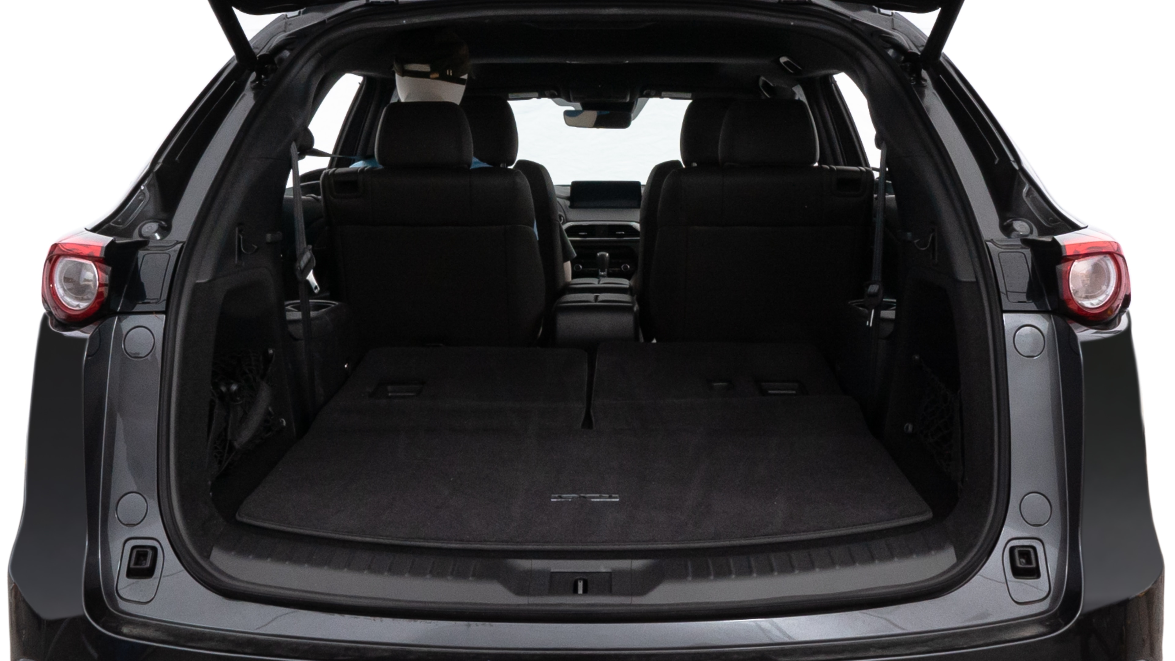 The trunk lid is open, showing full view of the trunk space. One large, two medium, and two small suitcases are placed inside.