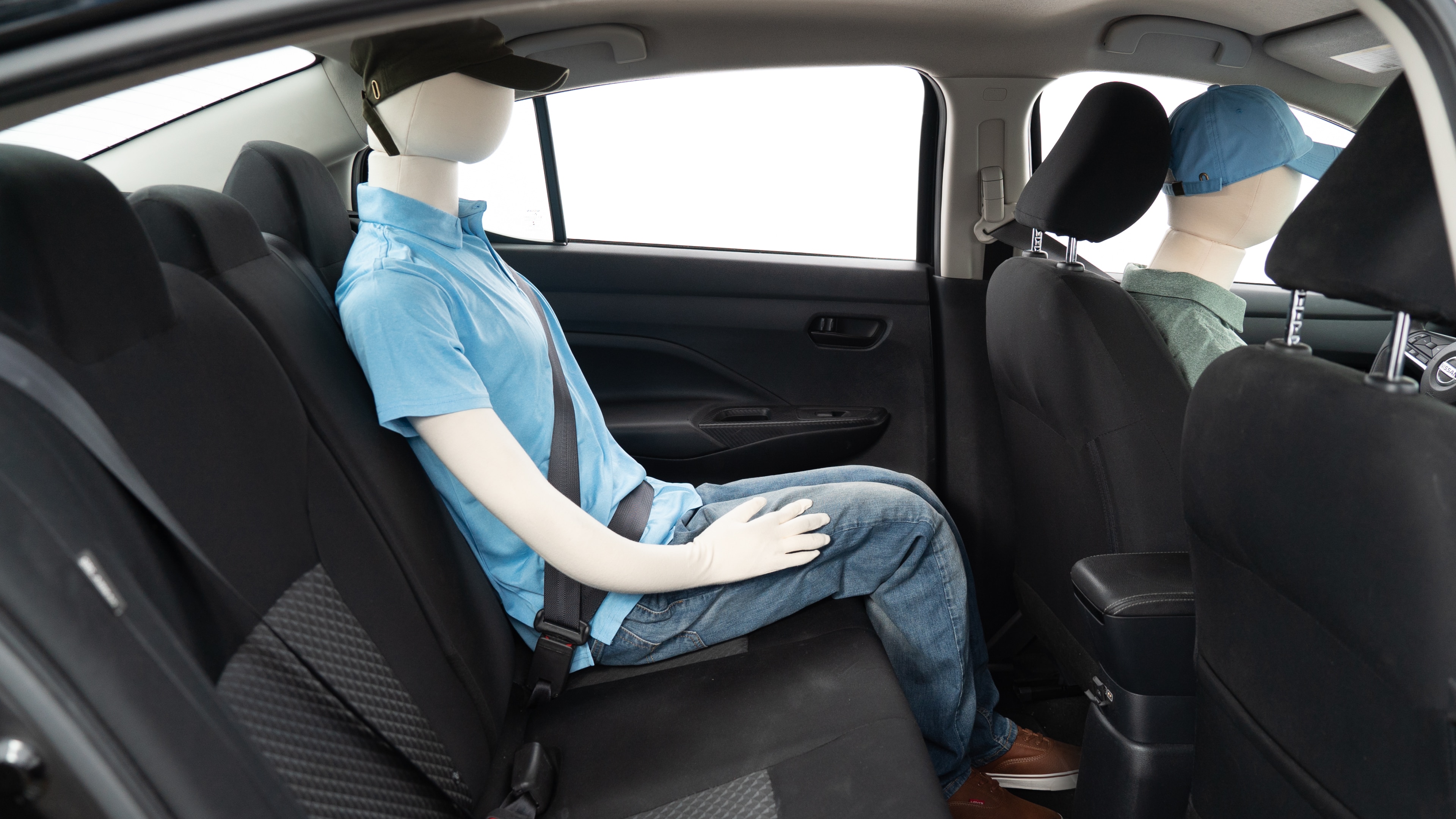 A series of second-row backseat photos is shown including one seating a baby seat, a dog and one seating a 6'1" mannequin.