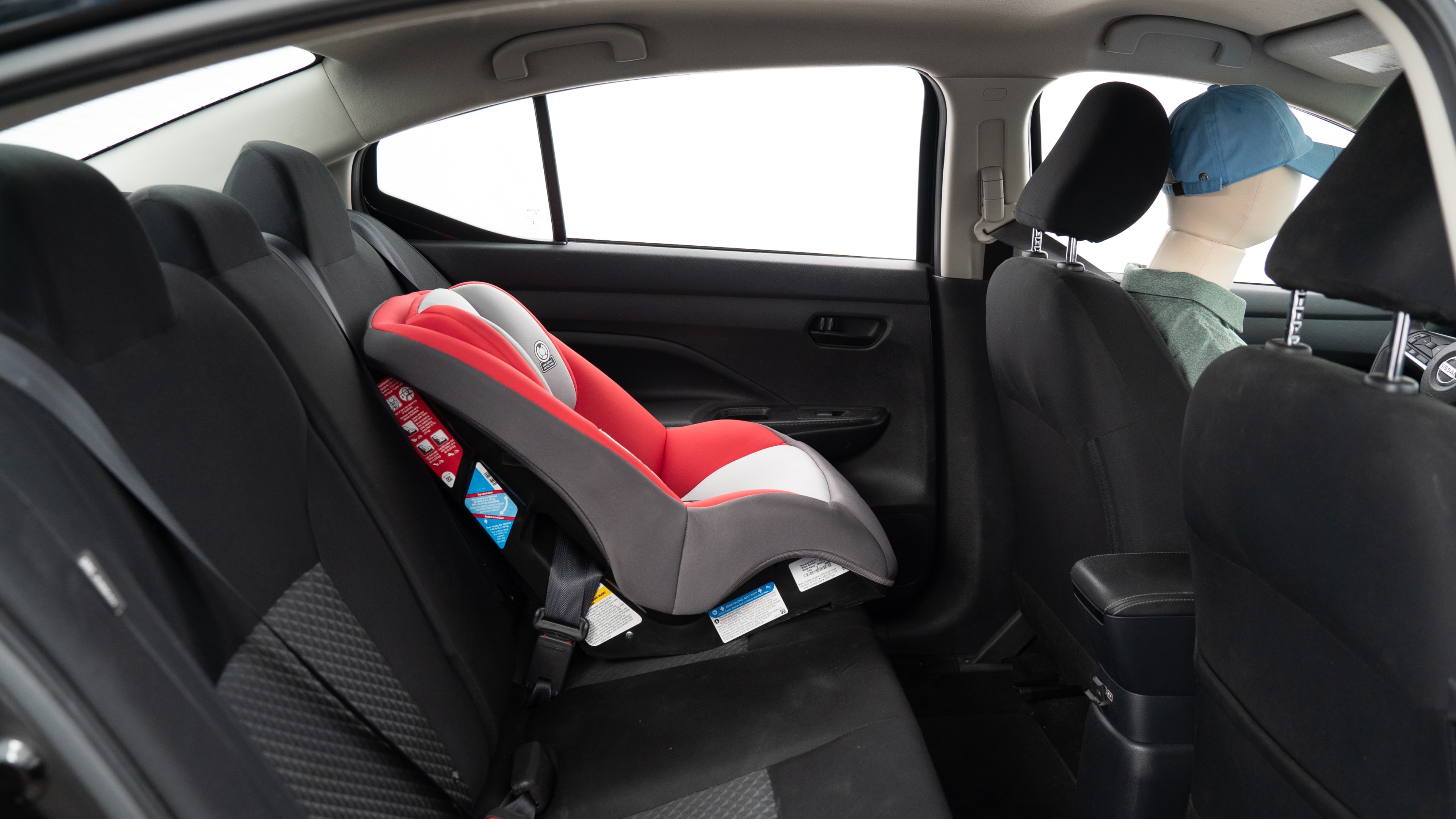 A series of second-row backseat photos is shown including one seating a baby seat, a dog and one seating a 6'1" mannequin.