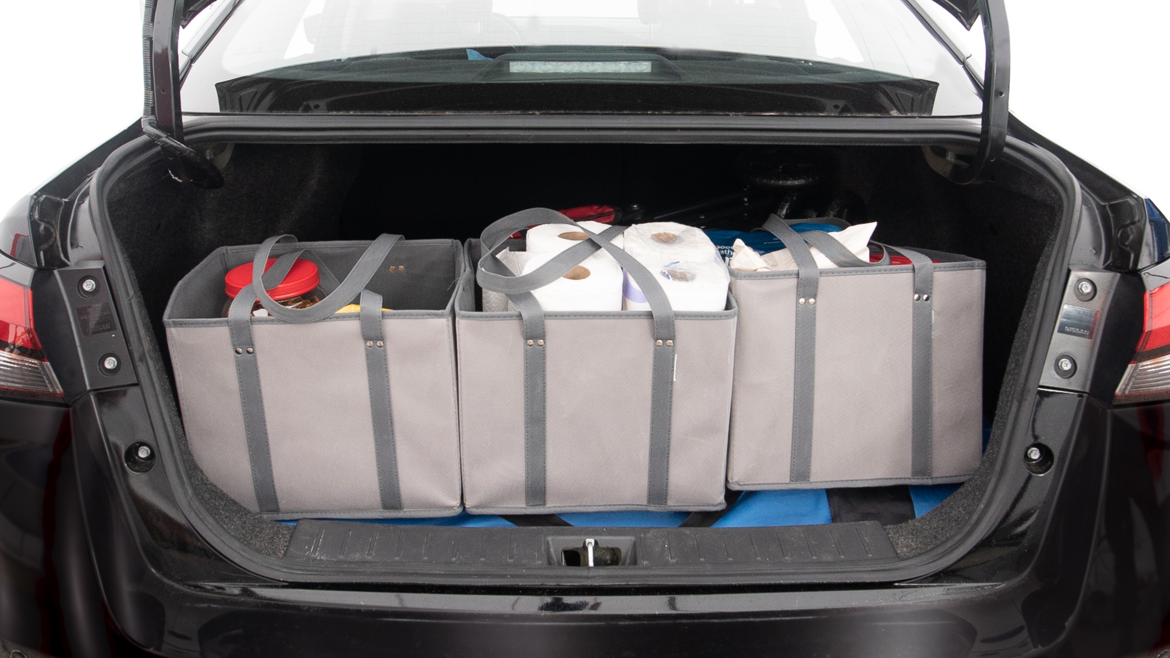The trunk lid is open showing full view of the trunk. A baby stroller, three grocery carriers, two camping chairs in the carrying bag, and a set of golf clubs are placed inside.