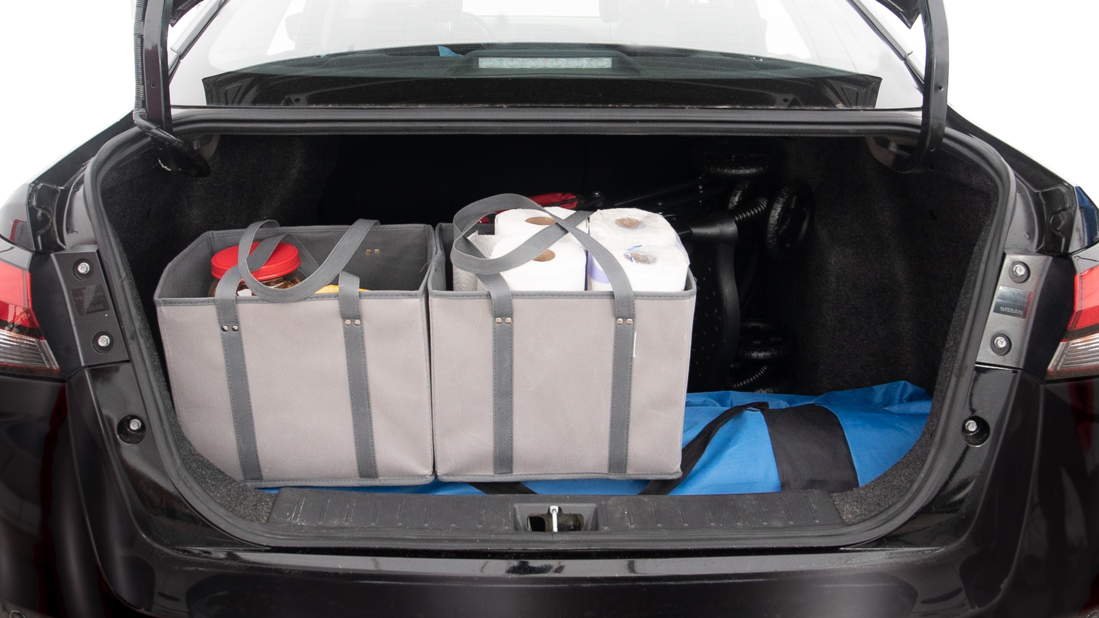 The trunk lid is open showing full view of the trunk. A baby stroller, three grocery carriers, two camping chairs in the carrying bag, and a set of golf clubs are placed inside.