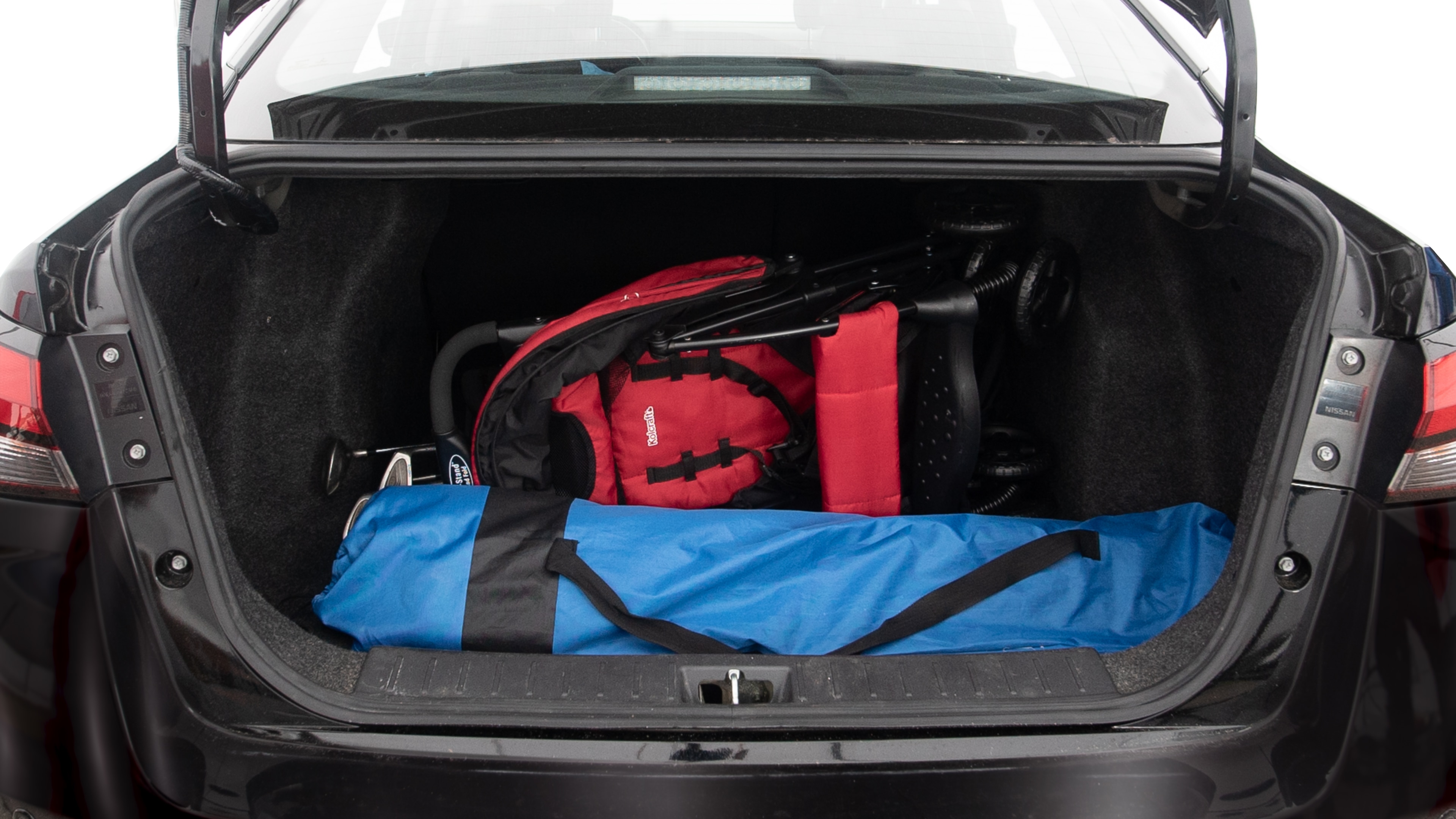 The trunk lid is open showing full view of the trunk. A baby stroller, three grocery carriers, two camping chairs in the carrying bag, and a set of golf clubs are placed inside.