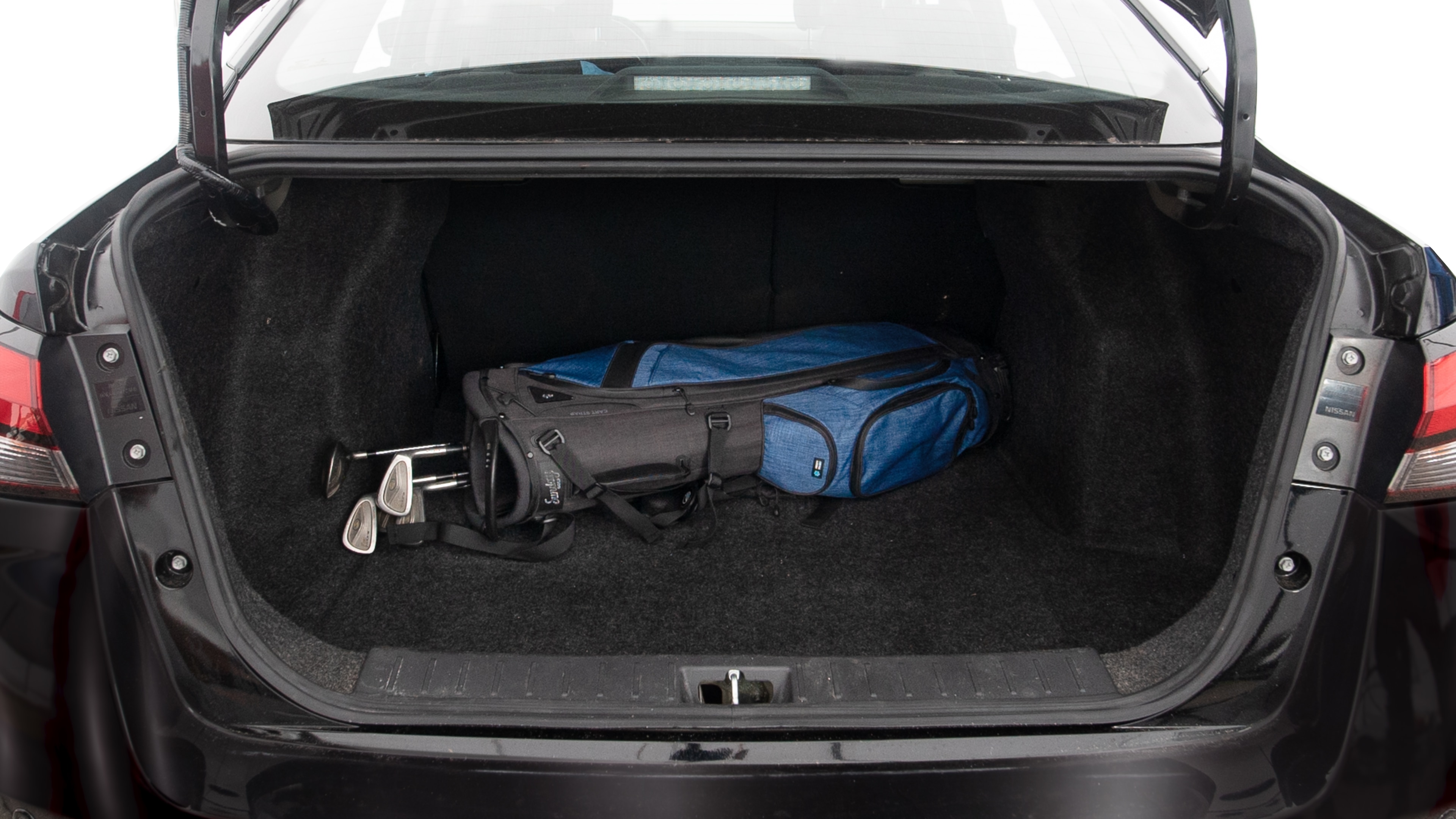 The trunk lid is open showing full view of the trunk. A baby stroller, three grocery carriers, two camping chairs in the carrying bag, and a set of golf clubs are placed inside.