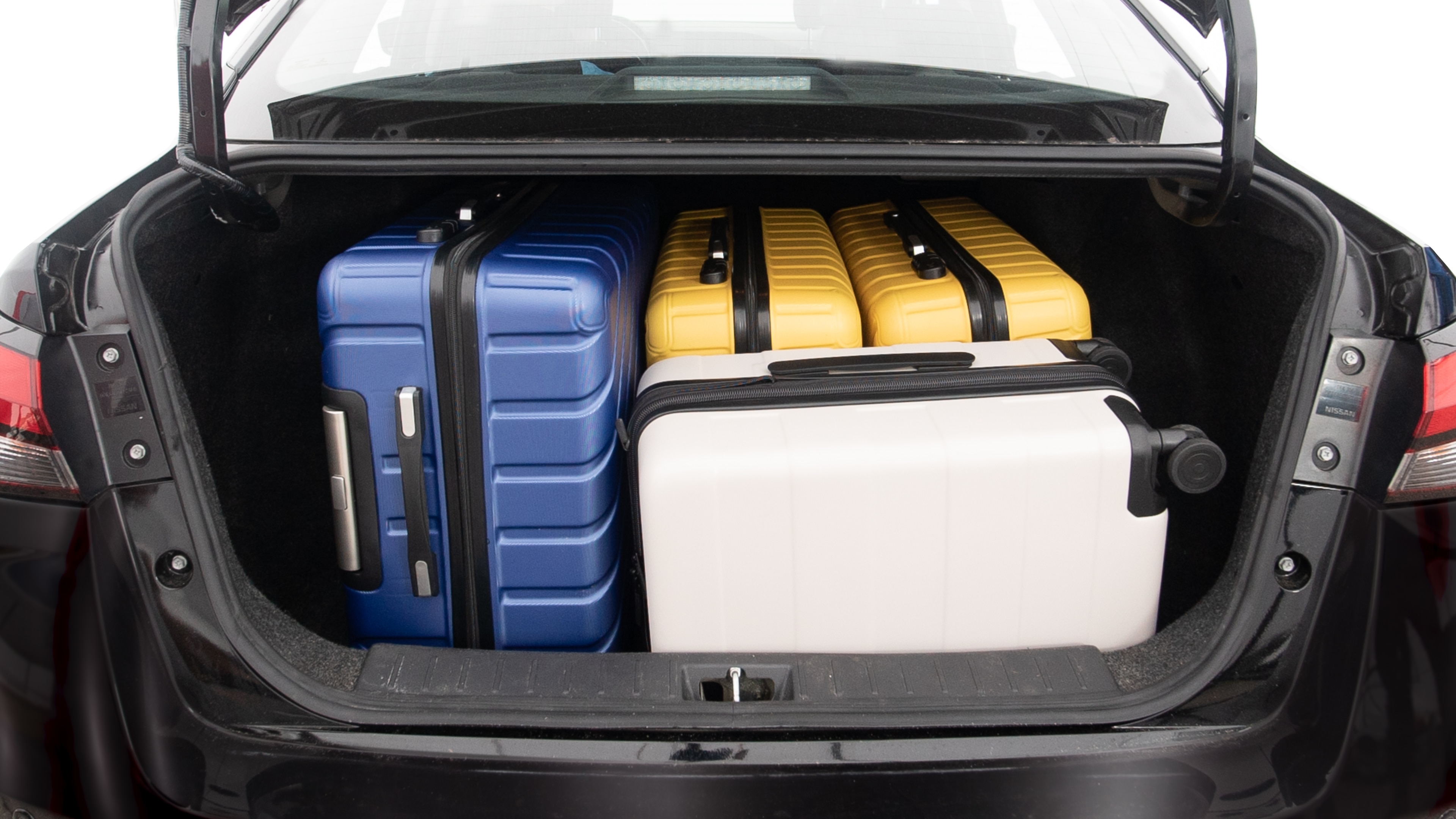 The trunk lid is open, showing full view of the trunk space. One extra large, two large and one small suitcases are placed inside.