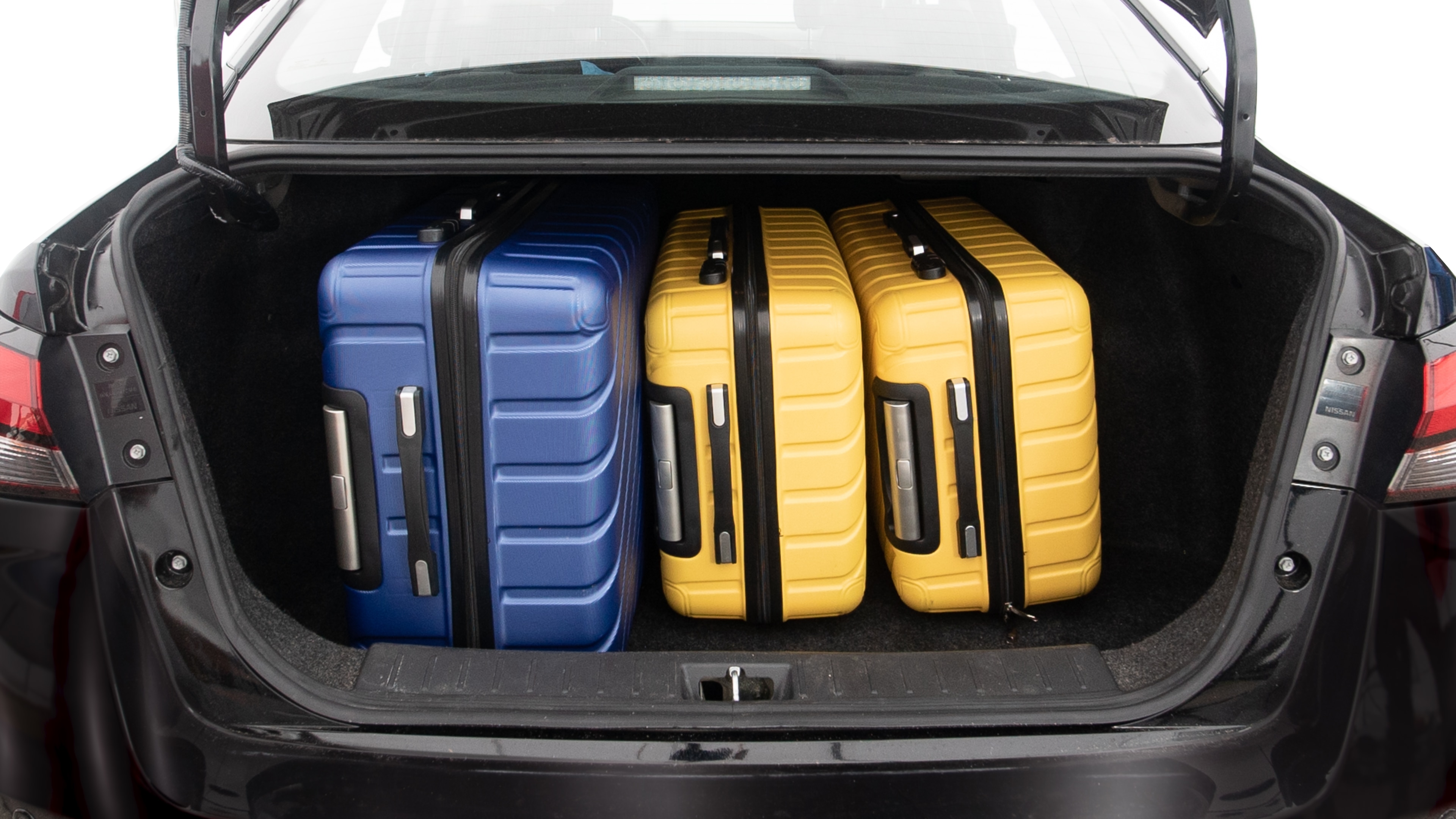 The trunk lid is open, showing full view of the trunk space. One extra large, two large and one small suitcases are placed inside.