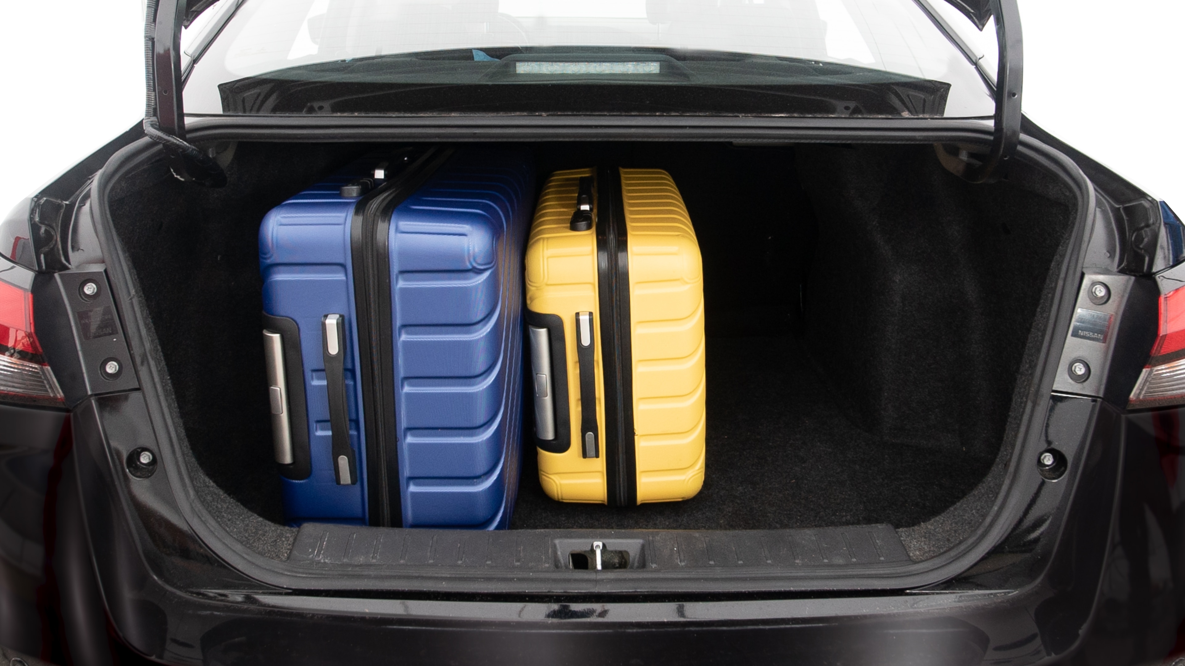The trunk lid is open, showing full view of the trunk space. One extra large, two large and one small suitcases are placed inside.