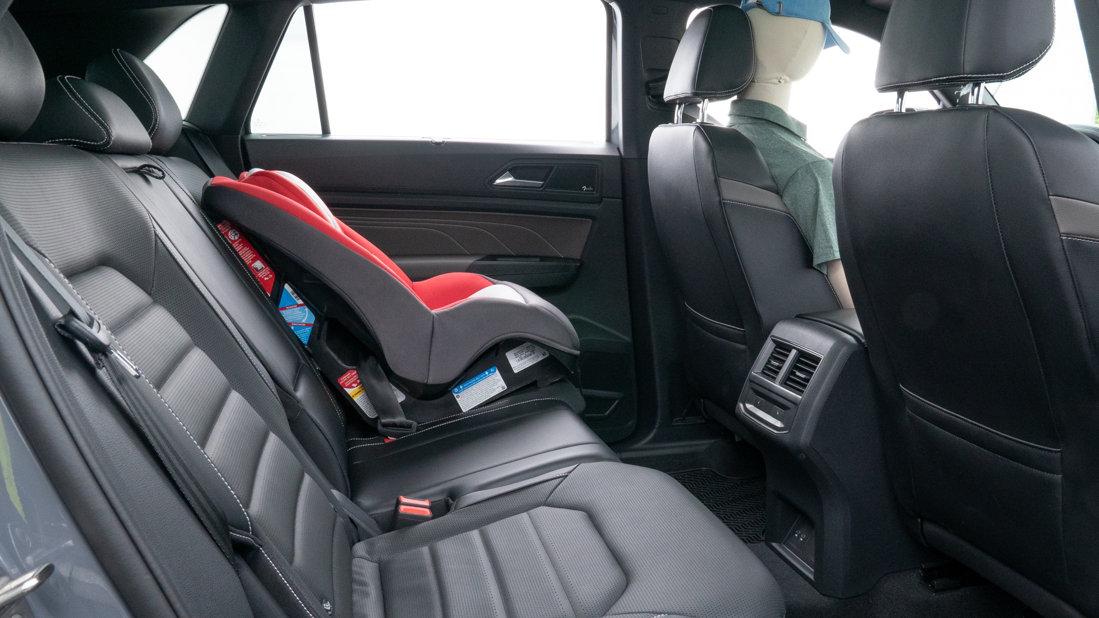 A series of second-row backseat photos is shown including one seating a baby seat and one seating a 6'1" mannequin.