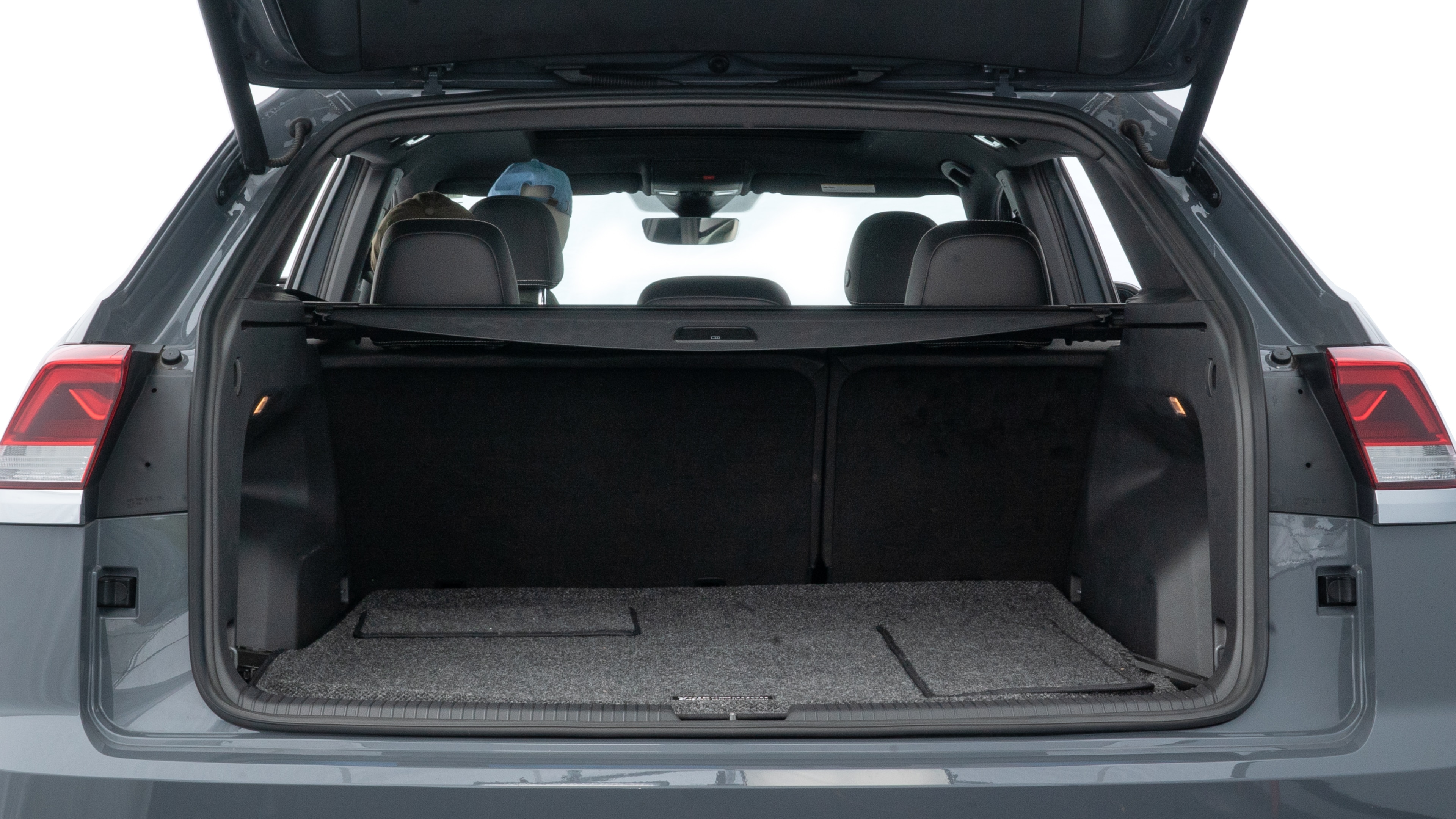 The trunk lid is open showing full view of the trunk. A baby stroller, three grocery carriers, two camping chairs in the carrying bag, and a set of golf clubs are placed inside.