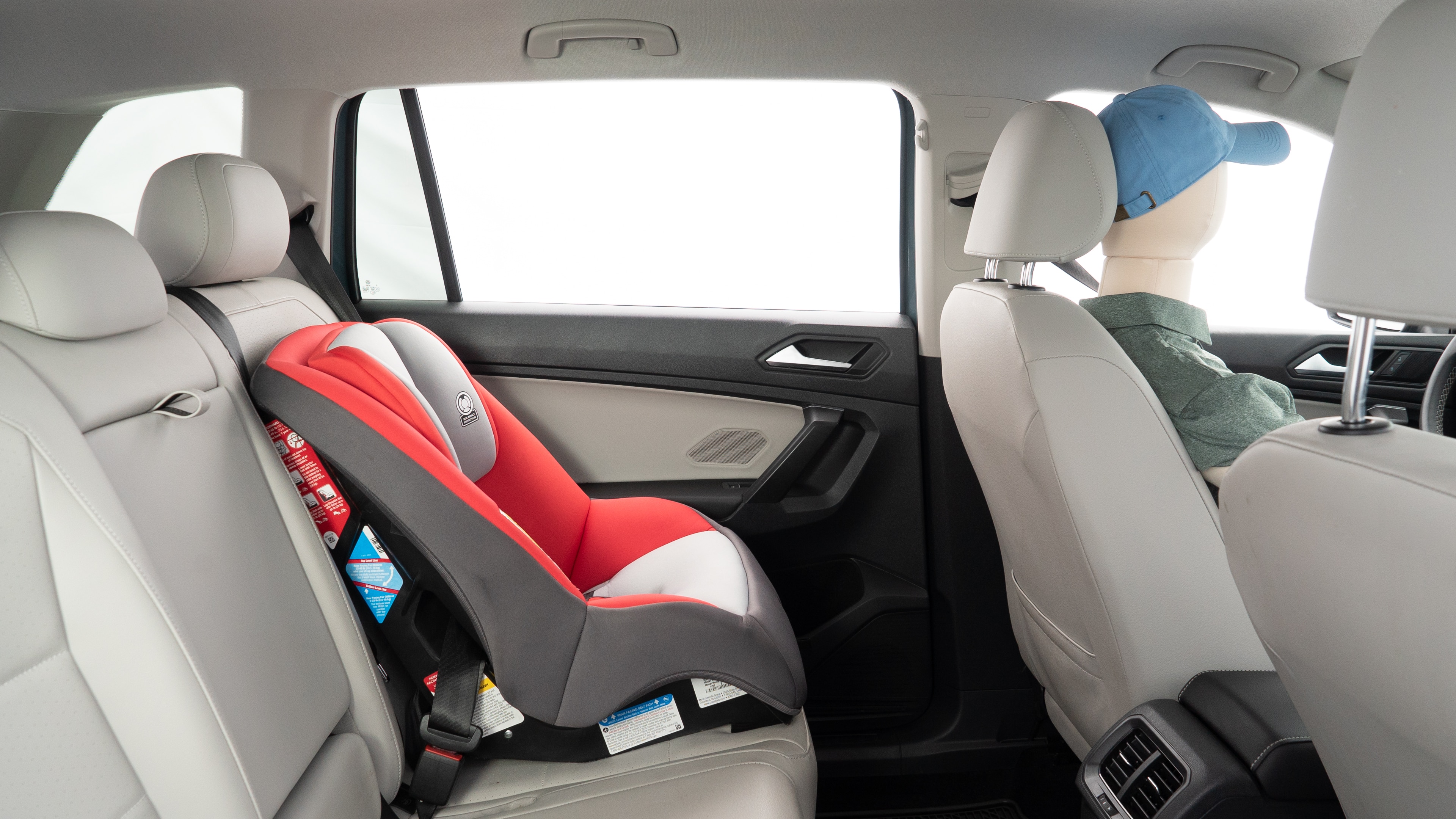 A series of second-row backseat photos is shown including one seating a baby seat and one seating a 6'1" mannequin.