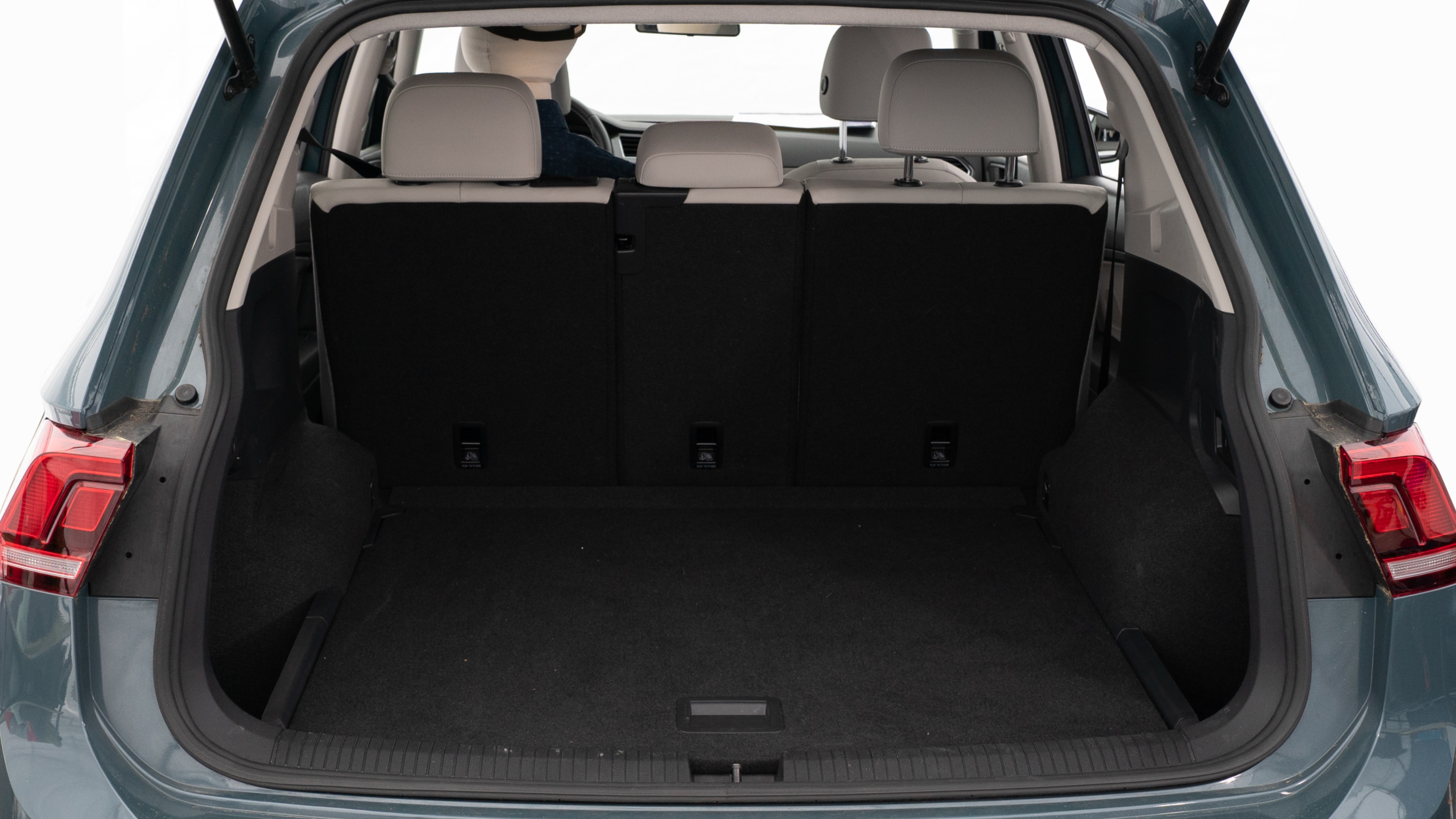 The trunk lid is open, showing a full view of the trunk space. Three large and two small suitcases are placed inside.