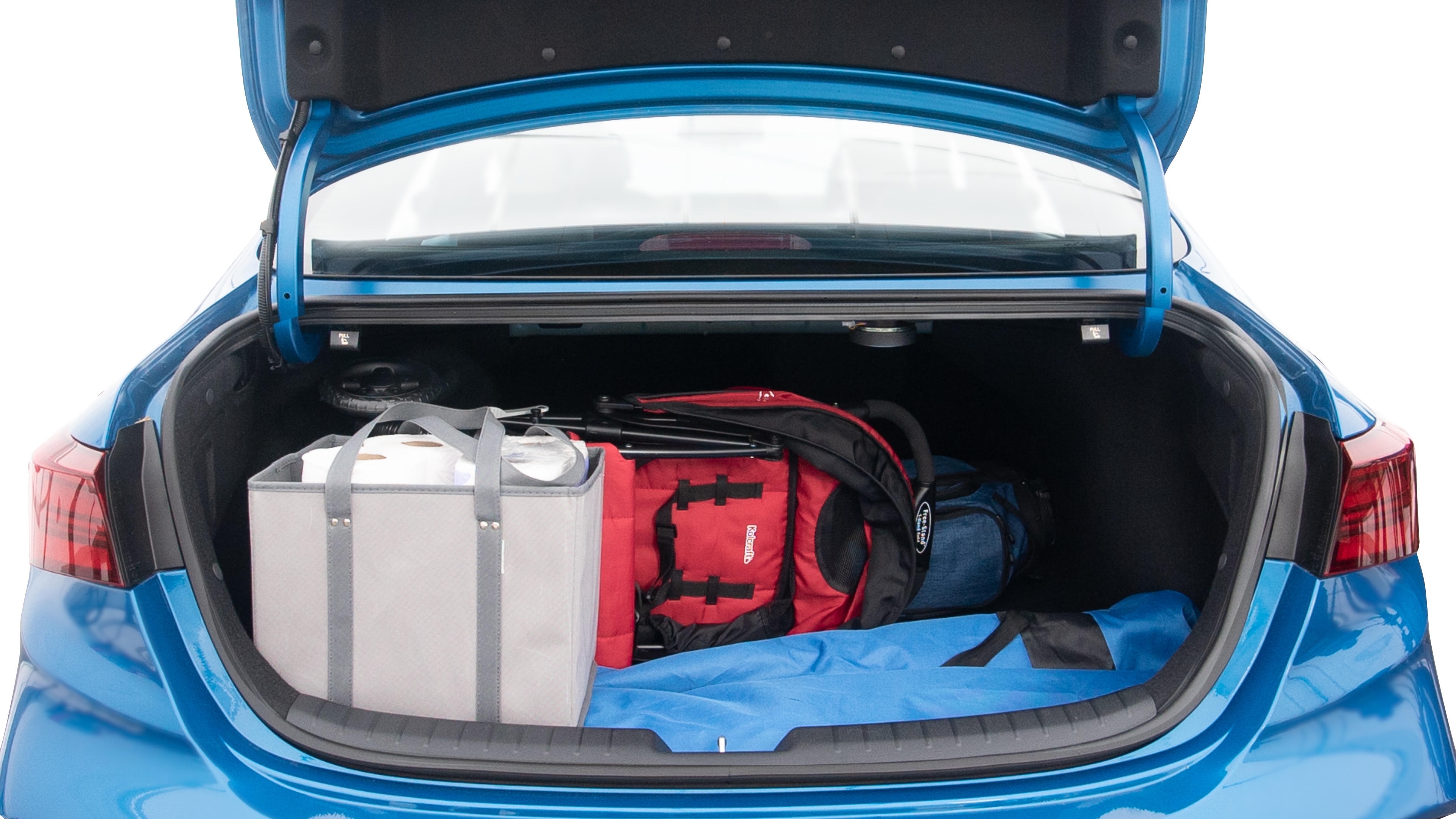 The trunk lid is open showing full view of the trunk. A baby stroller, three grocery carriers, two camping chairs in the carrying bag, and a set of golf clubs are placed inside.