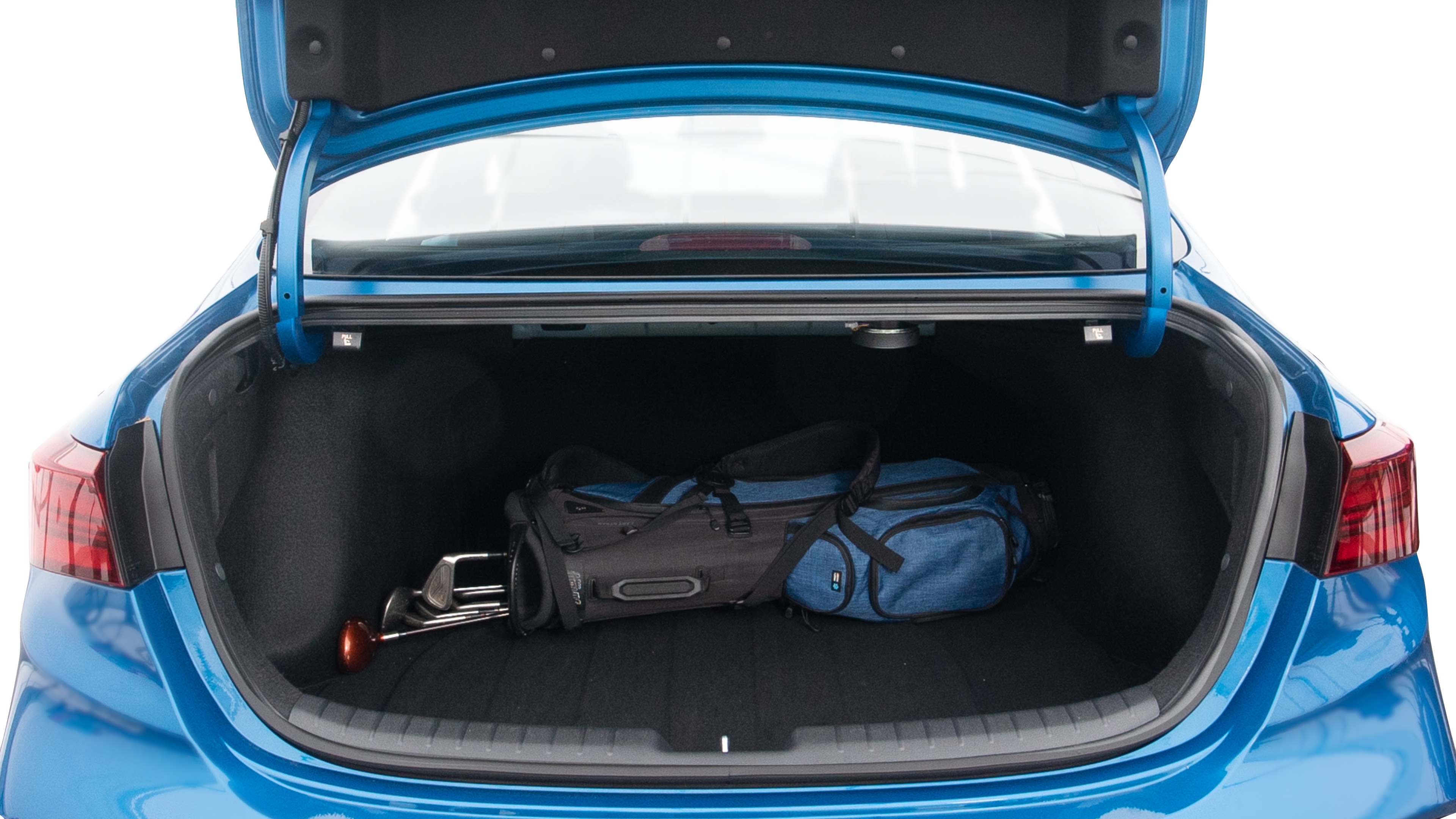 The trunk lid is open showing full view of the trunk. A baby stroller, three grocery carriers, two camping chairs in the carrying bag, and a set of golf clubs are placed inside.