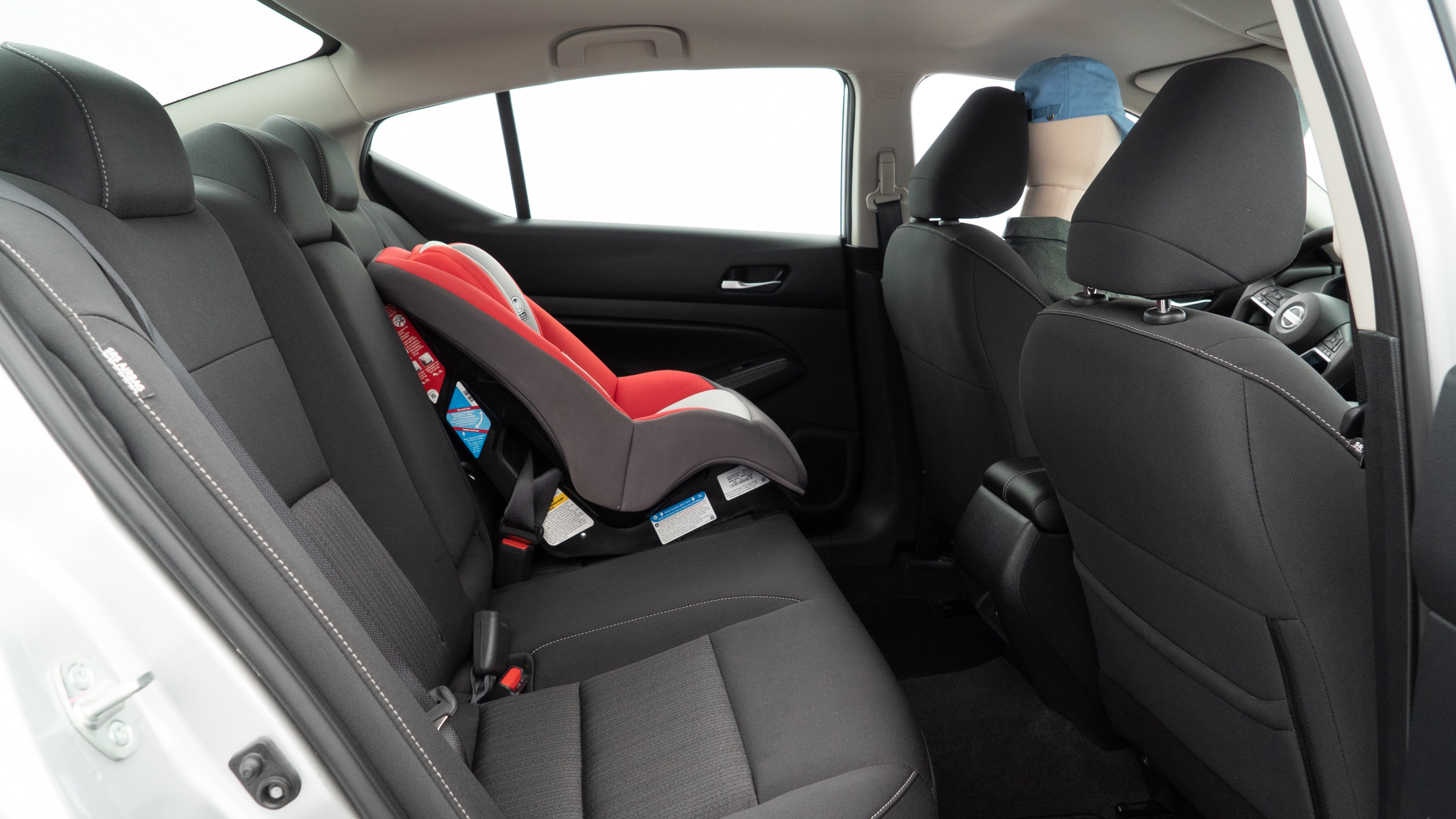 A series of second-row backseat photos is shown including one seating a baby seat and one seating a 6'1" mannequin.