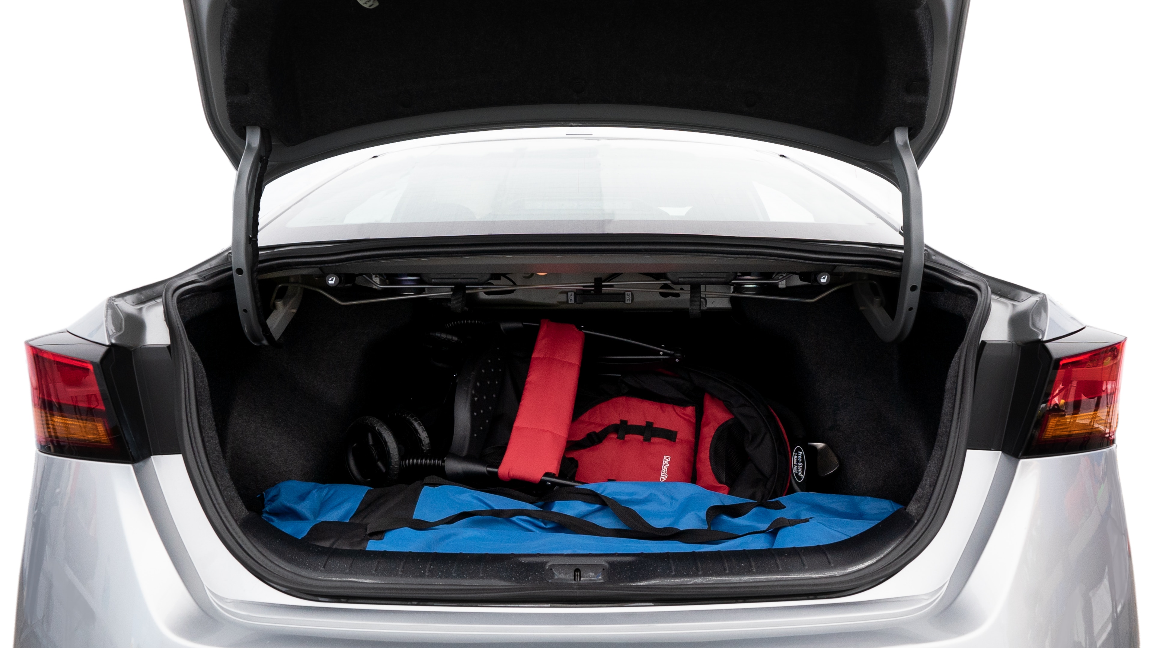 The trunk lid is open showing full view of the trunk. A baby stroller, three grocery carriers, two camping chairs in the carrying bag, and a set of golf clubs are placed inside.