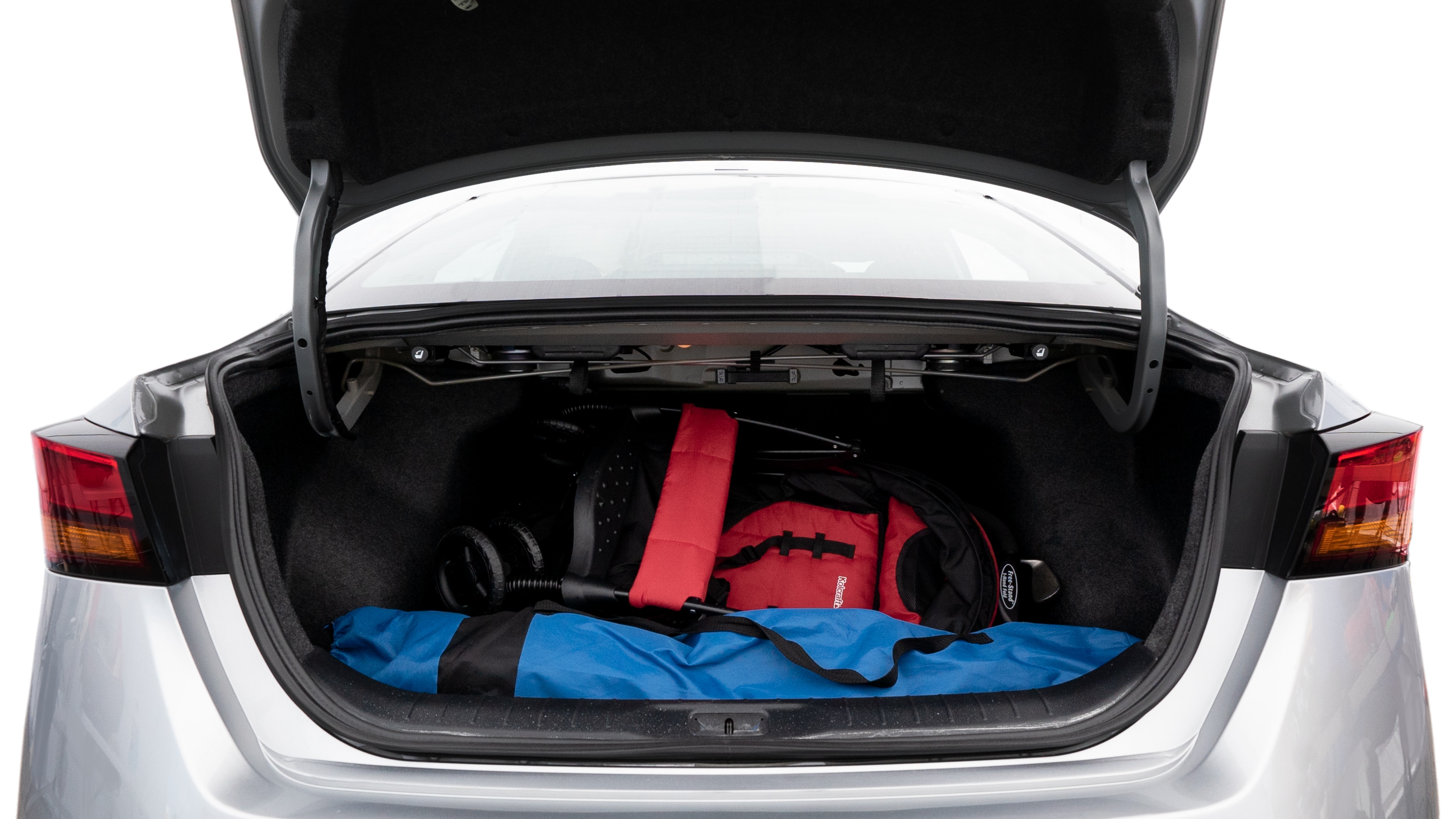 The trunk lid is open showing full view of the trunk. A baby stroller, three grocery carriers, two camping chairs in the carrying bag, and a set of golf clubs are placed inside.