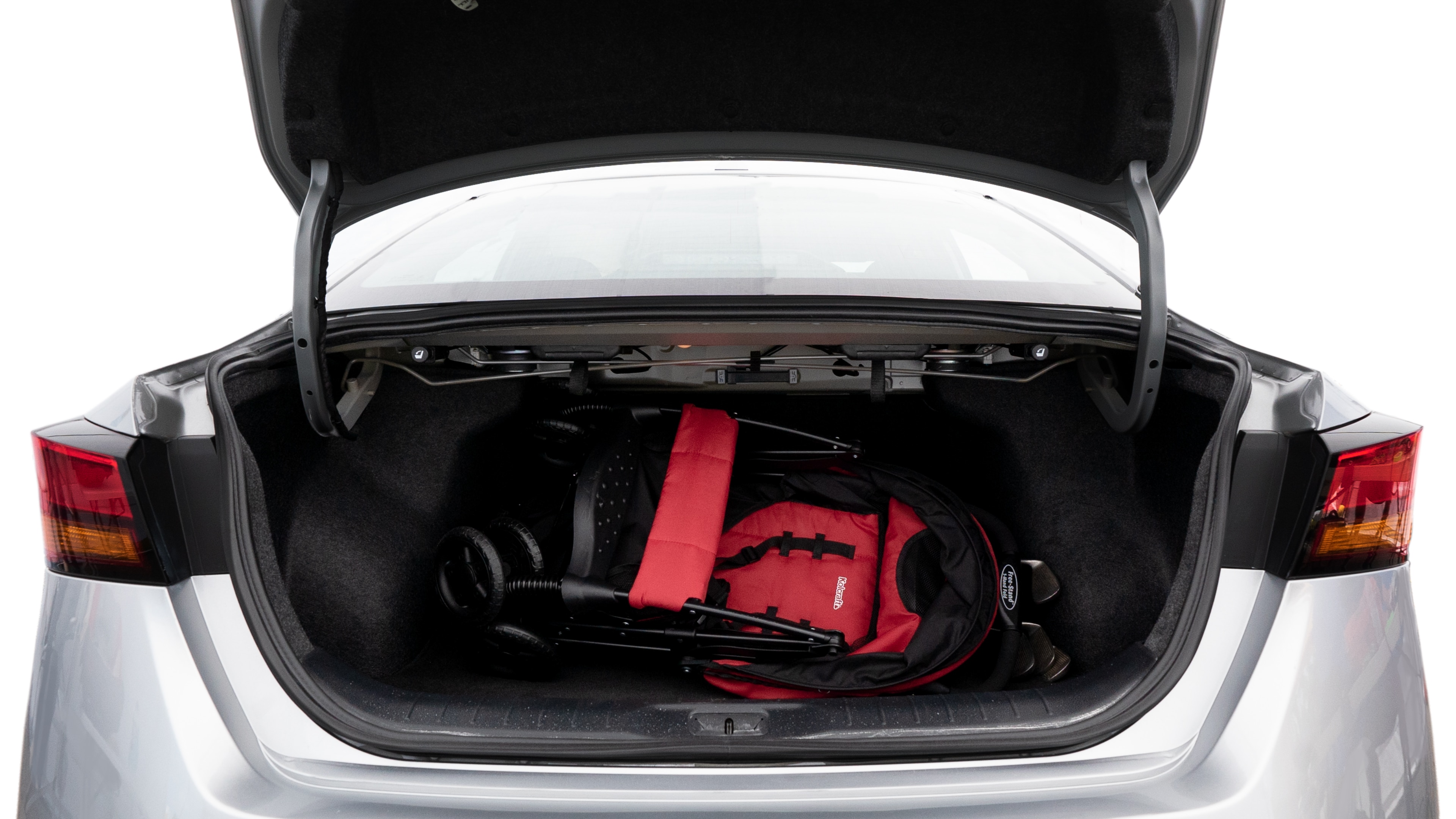 The trunk lid is open showing full view of the trunk. A baby stroller, three grocery carriers, two camping chairs in the carrying bag, and a set of golf clubs are placed inside.