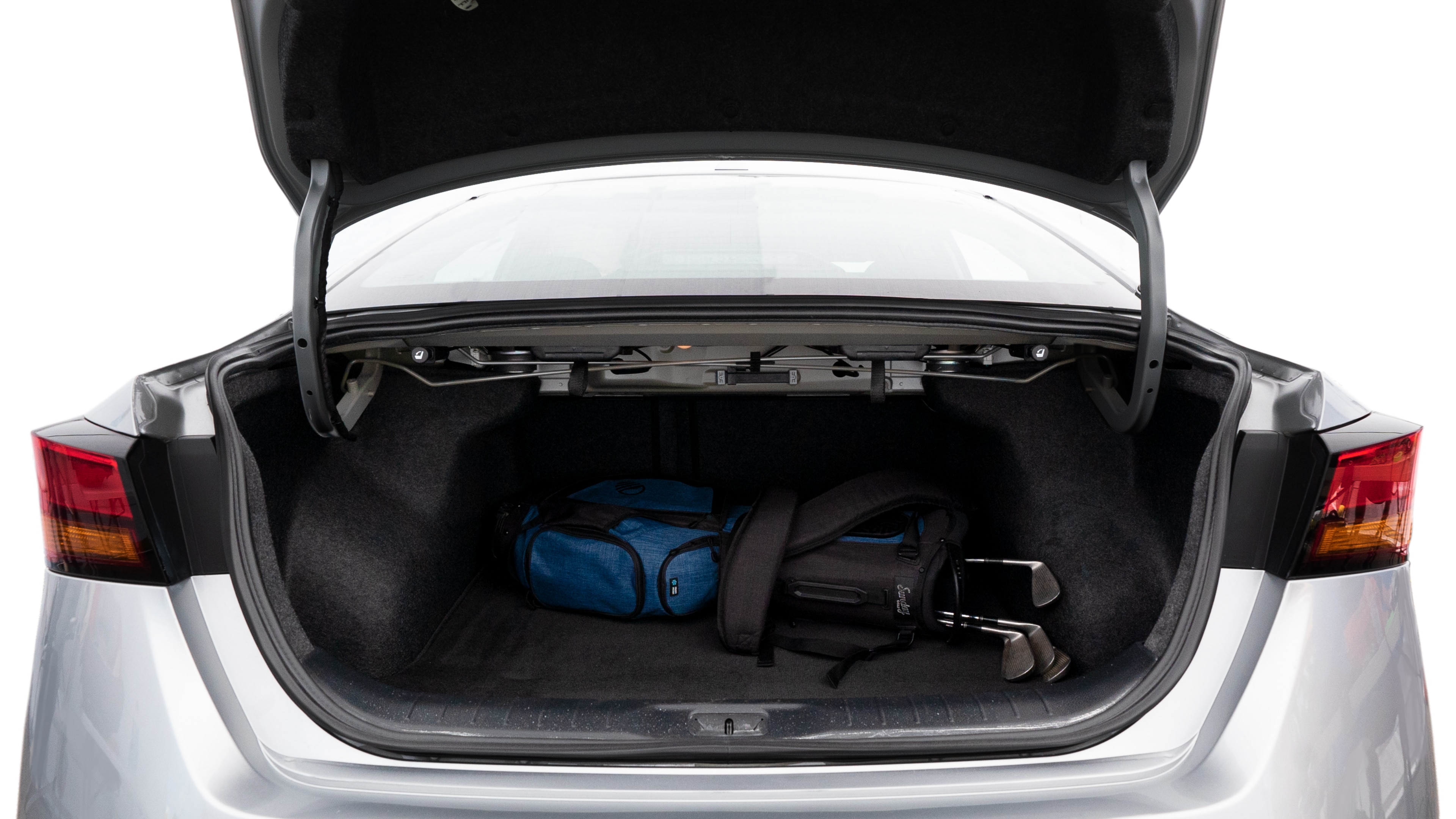 The trunk lid is open showing full view of the trunk. A baby stroller, three grocery carriers, two camping chairs in the carrying bag, and a set of golf clubs are placed inside.