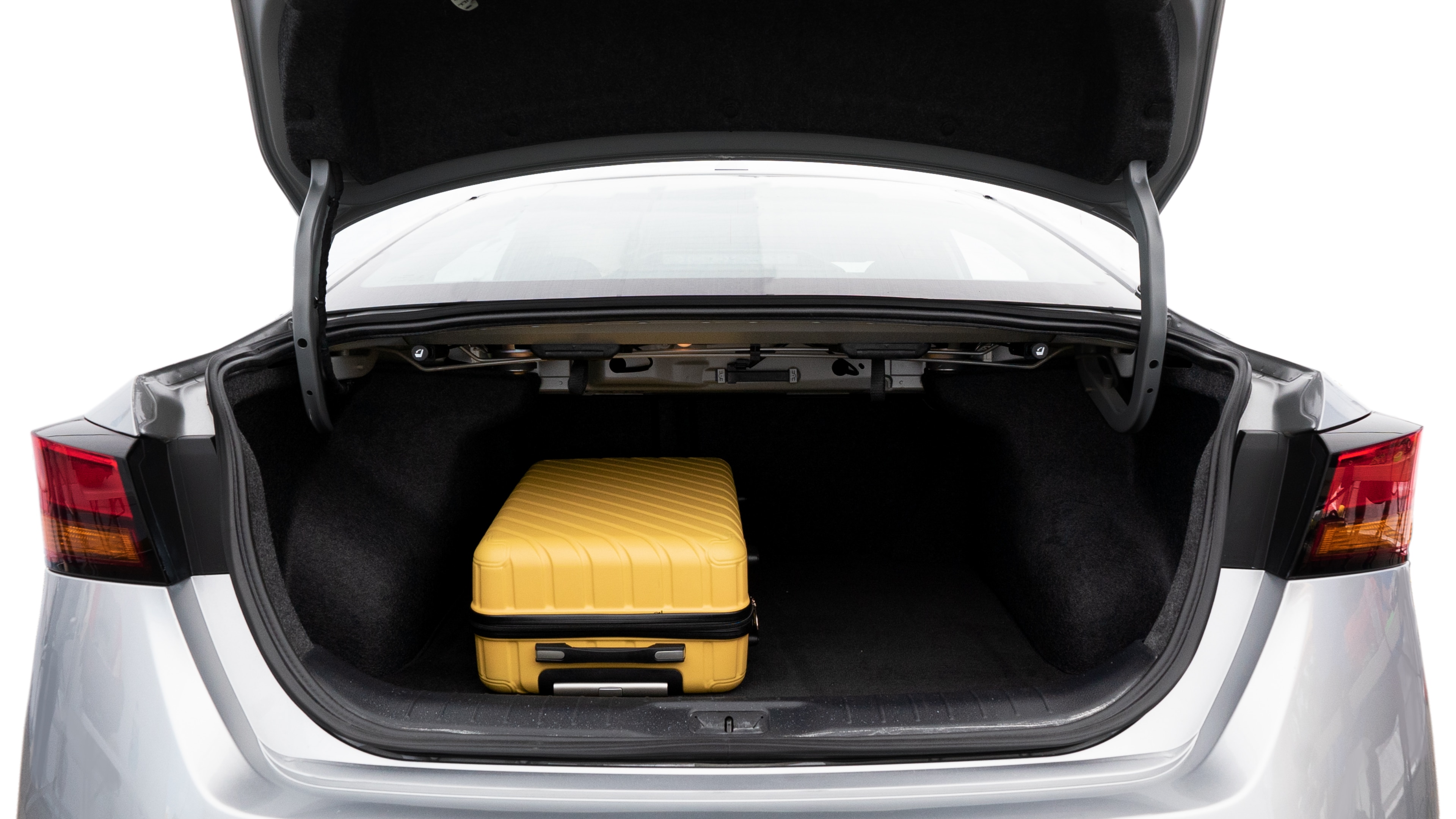 The trunk lid is open, showing full view of the trunk space. Two medium and two small suitcases are placed inside.