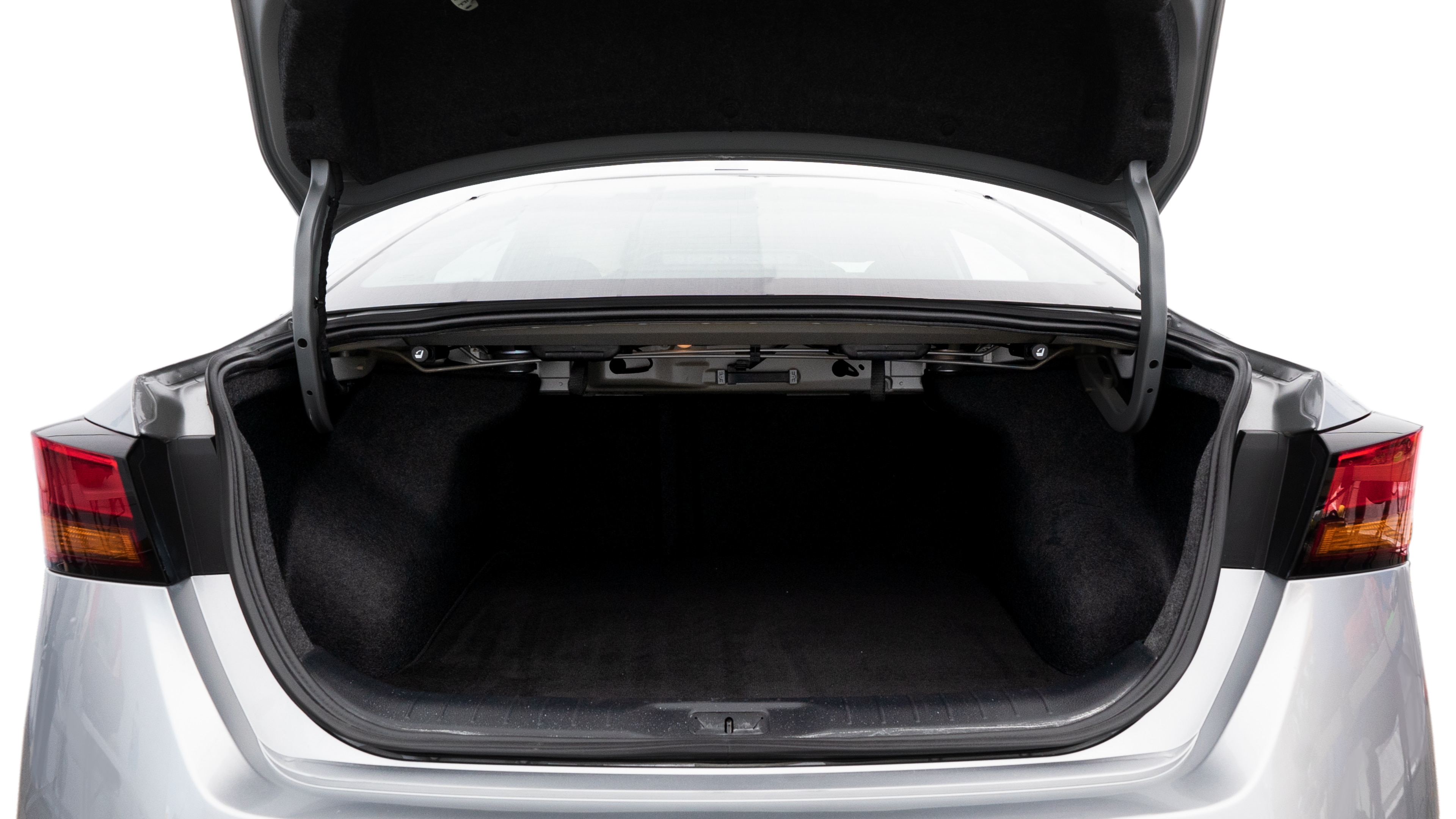The trunk lid is open, showing full view of the trunk space. Two medium and two small suitcases are placed inside.