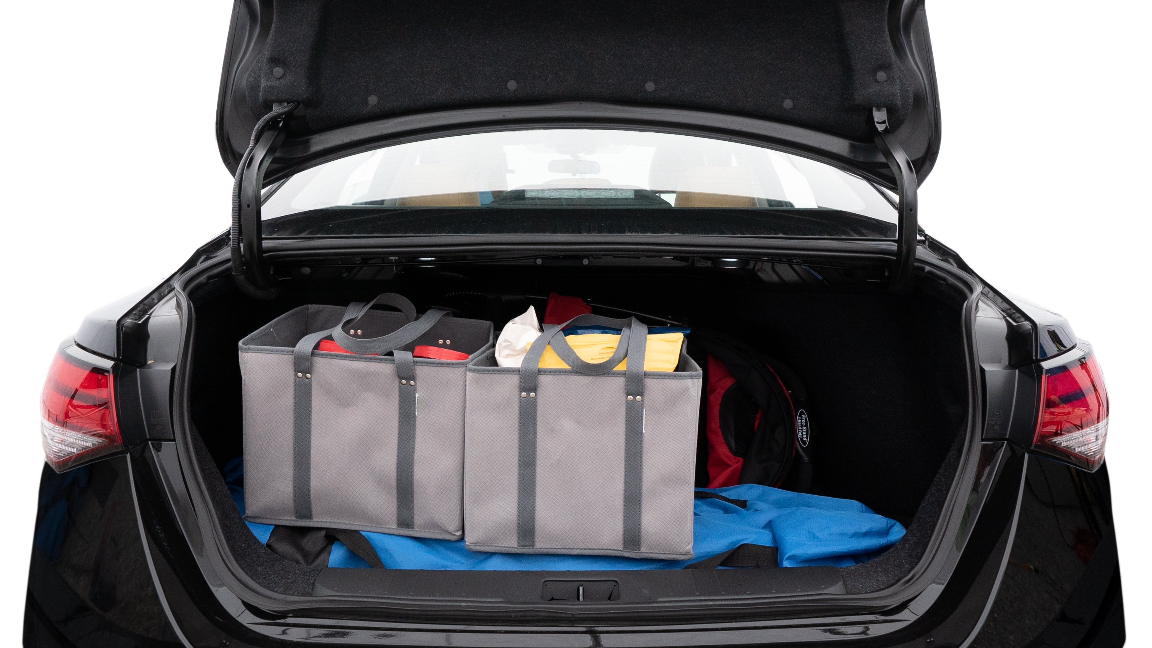 The trunk lid is open showing full view of the trunk. A baby stroller, three grocery carriers, two camping chairs in the carrying bag, and a set of golf clubs are placed inside.