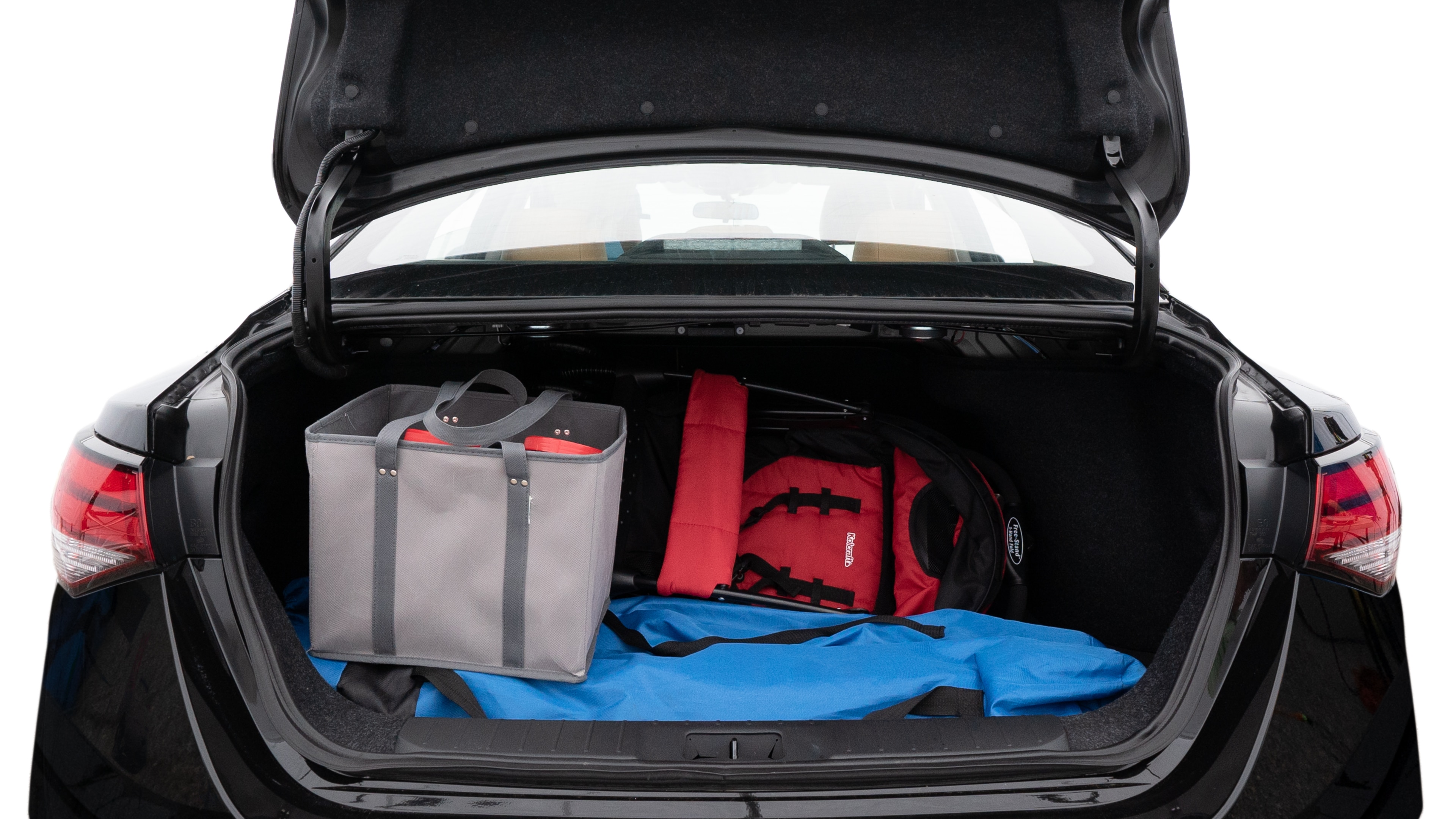 The trunk lid is open showing full view of the trunk. A baby stroller, three grocery carriers, two camping chairs in the carrying bag, and a set of golf clubs are placed inside.