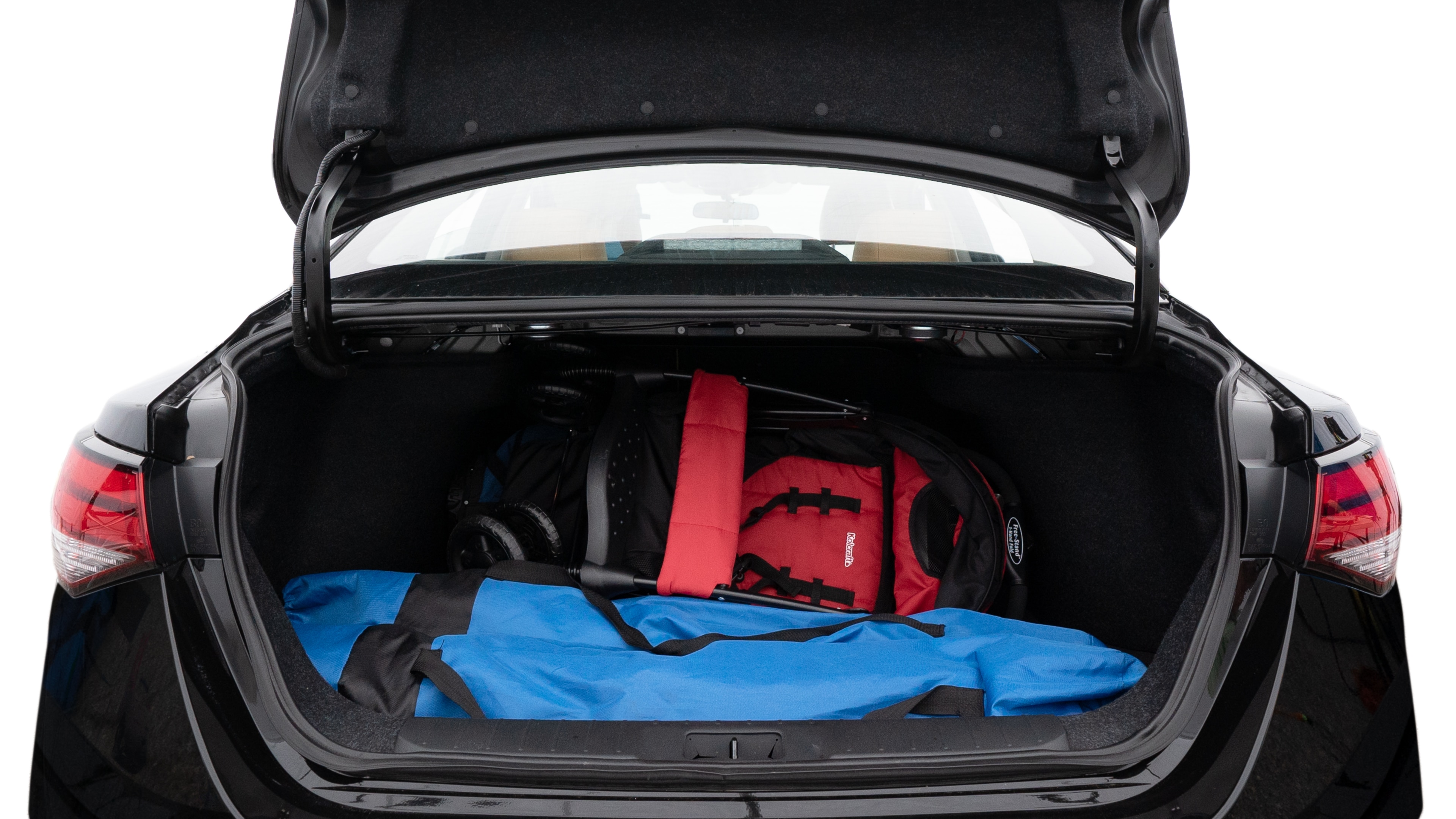 The trunk lid is open showing full view of the trunk. A baby stroller, three grocery carriers, two camping chairs in the carrying bag, and a set of golf clubs are placed inside.