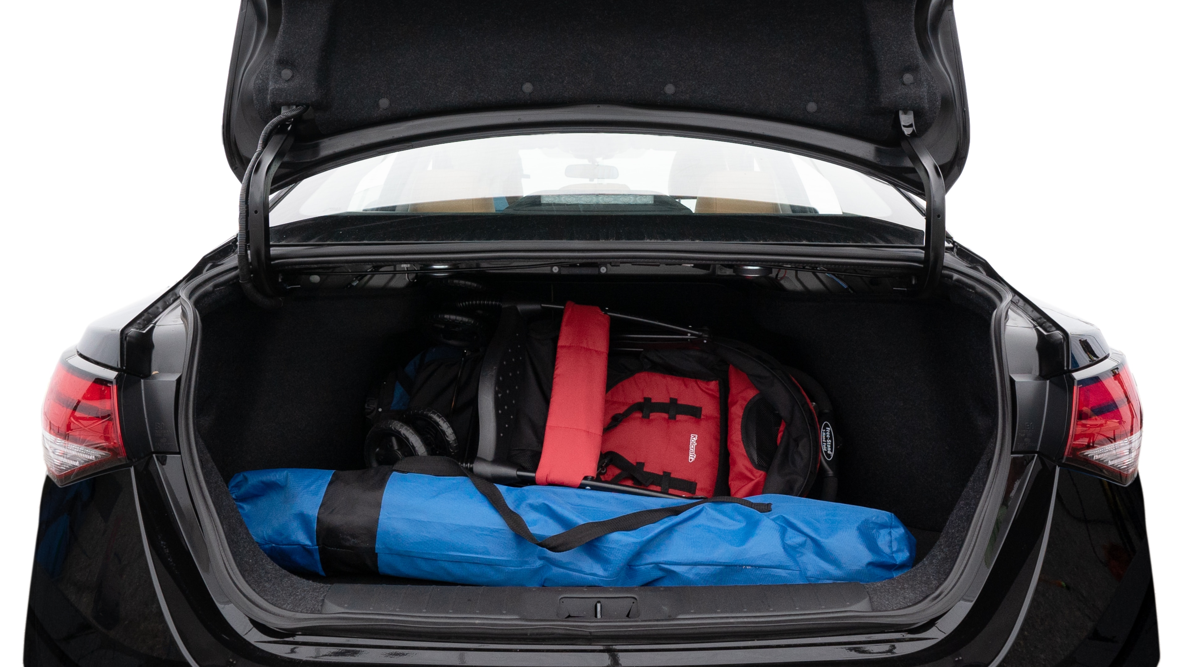 The trunk lid is open showing full view of the trunk. A baby stroller, three grocery carriers, two camping chairs in the carrying bag, and a set of golf clubs are placed inside.