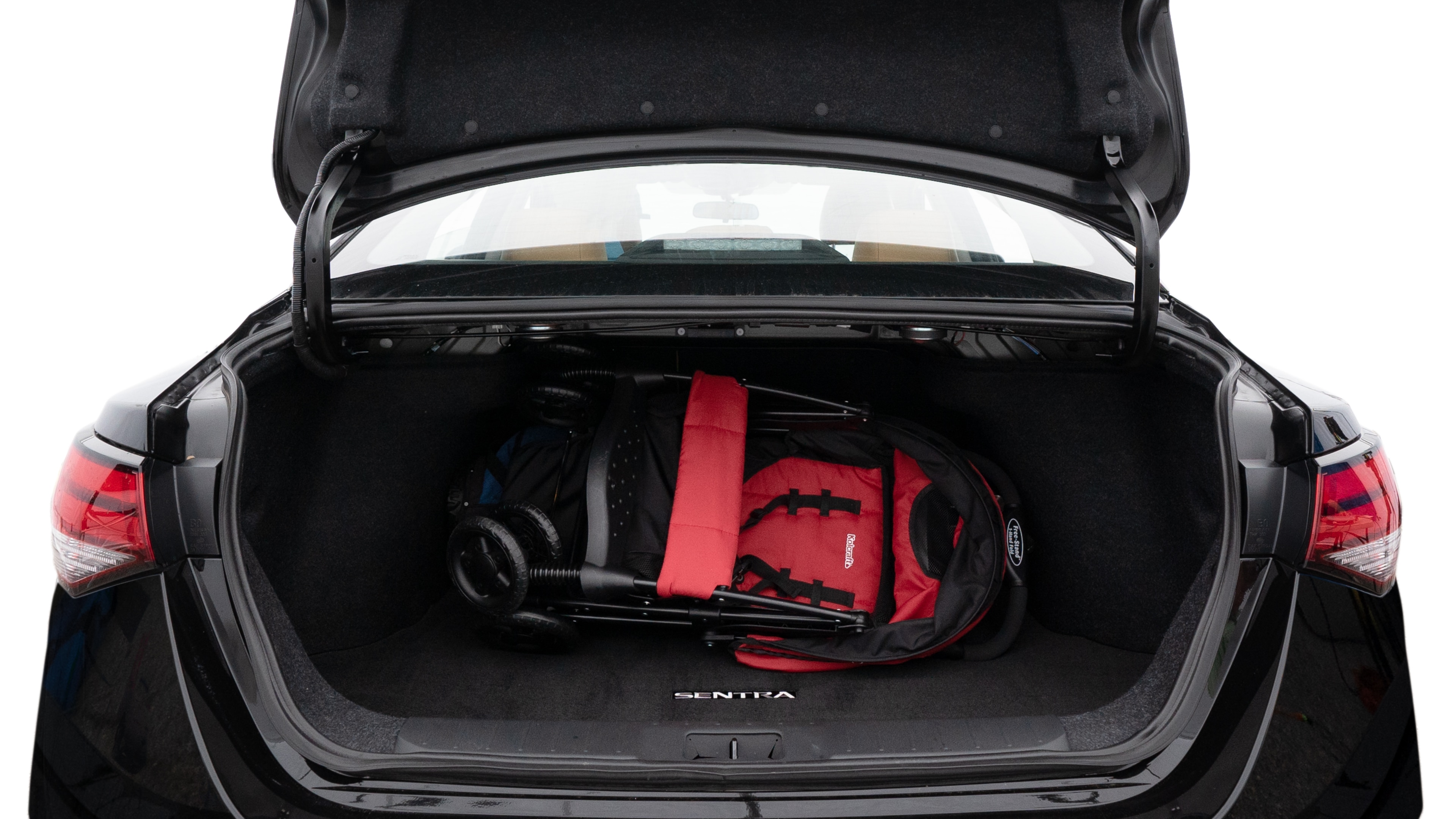 The trunk lid is open showing full view of the trunk. A baby stroller, three grocery carriers, two camping chairs in the carrying bag, and a set of golf clubs are placed inside.