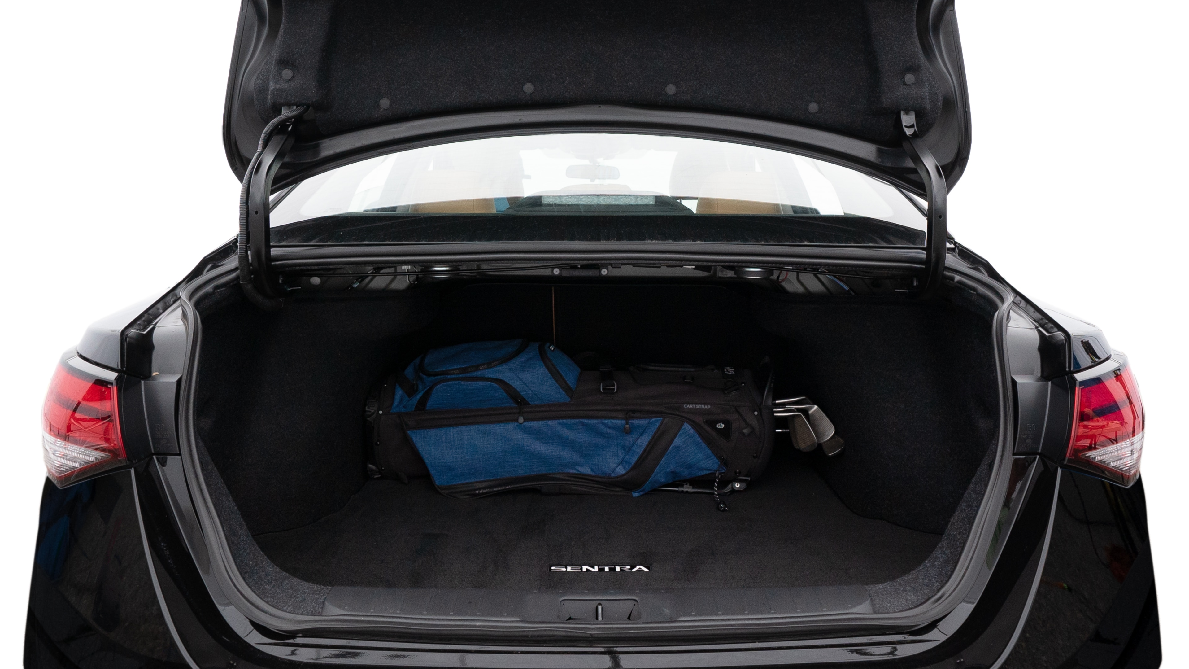 The trunk lid is open showing full view of the trunk. A baby stroller, three grocery carriers, two camping chairs in the carrying bag, and a set of golf clubs are placed inside.