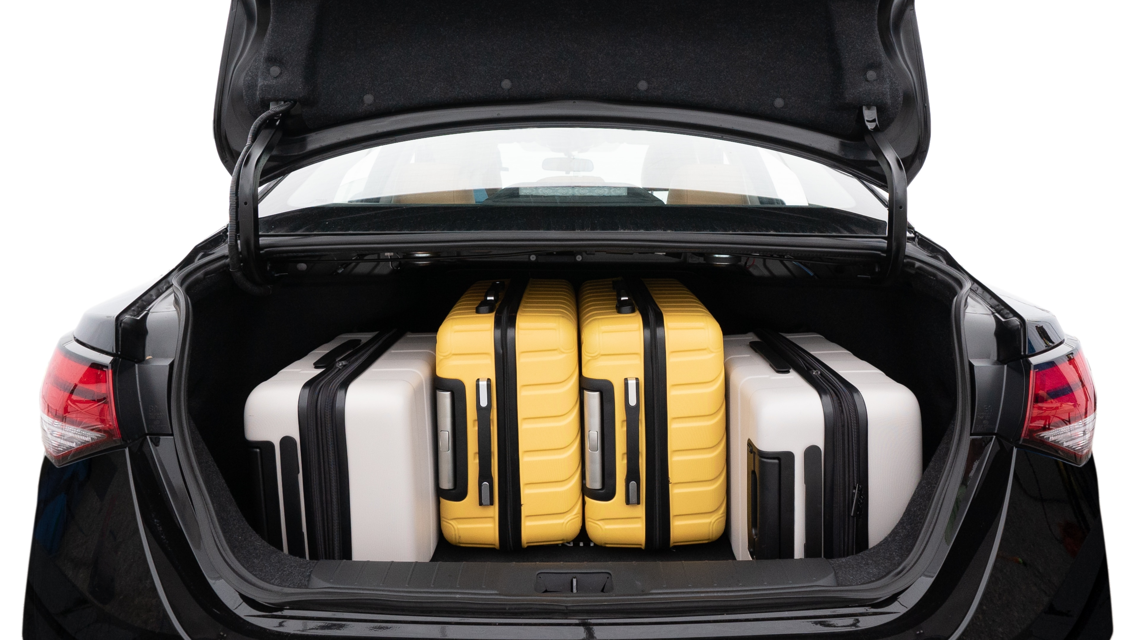 The trunk lid is open, showing full view of the trunk space. Two medium and two small suitcases are placed inside.