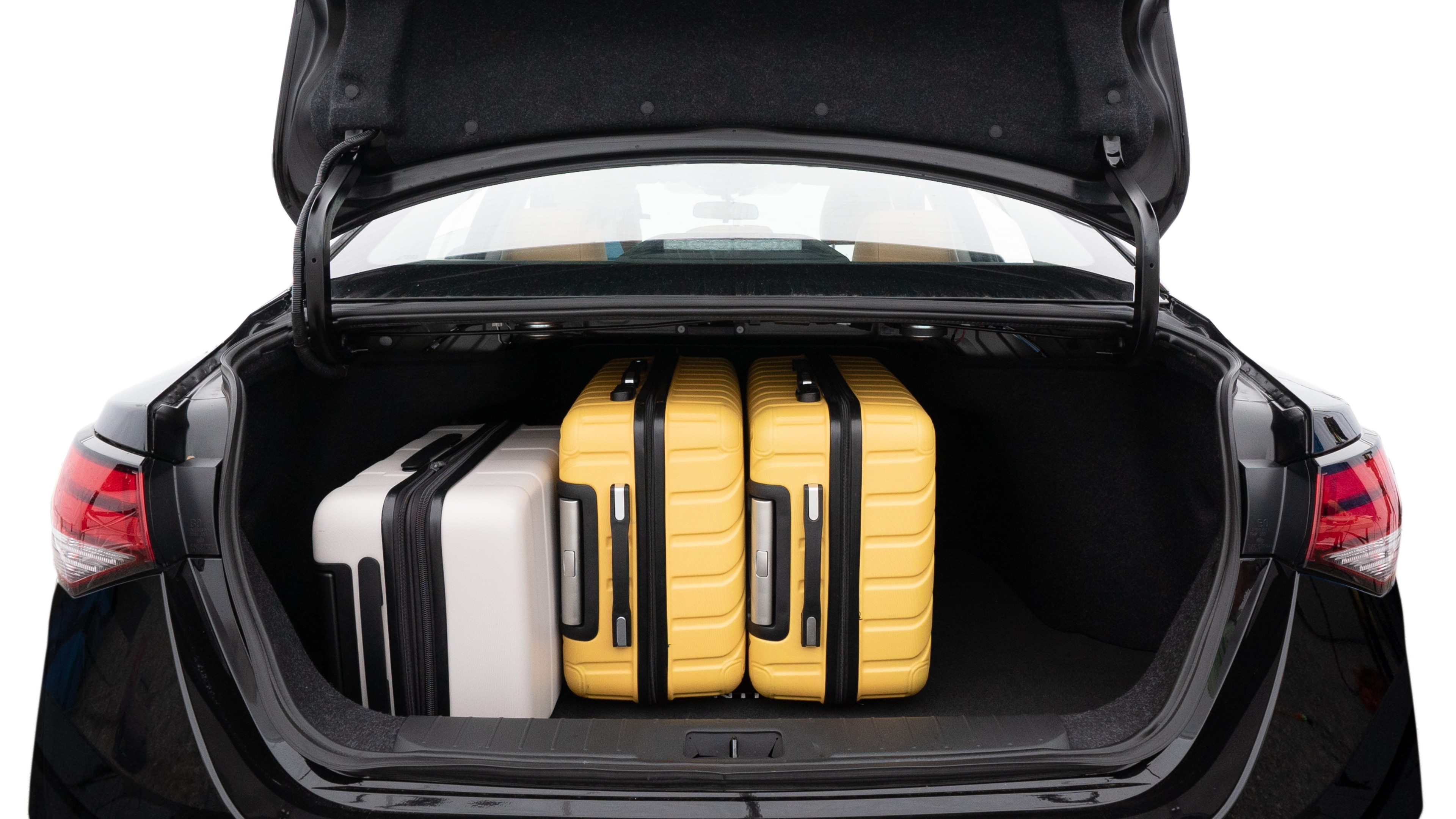The trunk lid is open, showing full view of the trunk space. Two medium and two small suitcases are placed inside.