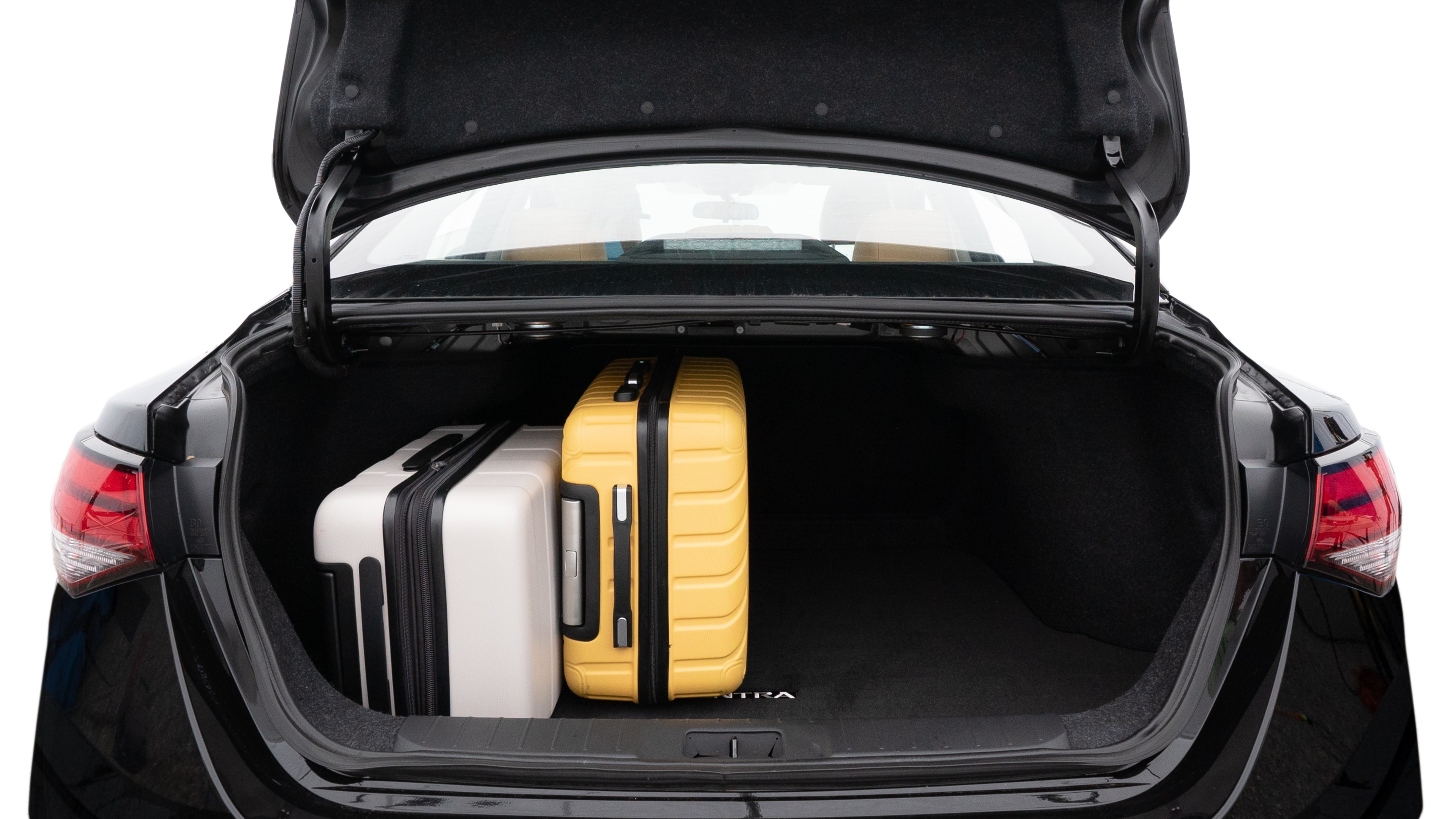 The trunk lid is open, showing full view of the trunk space. Two medium and two small suitcases are placed inside.