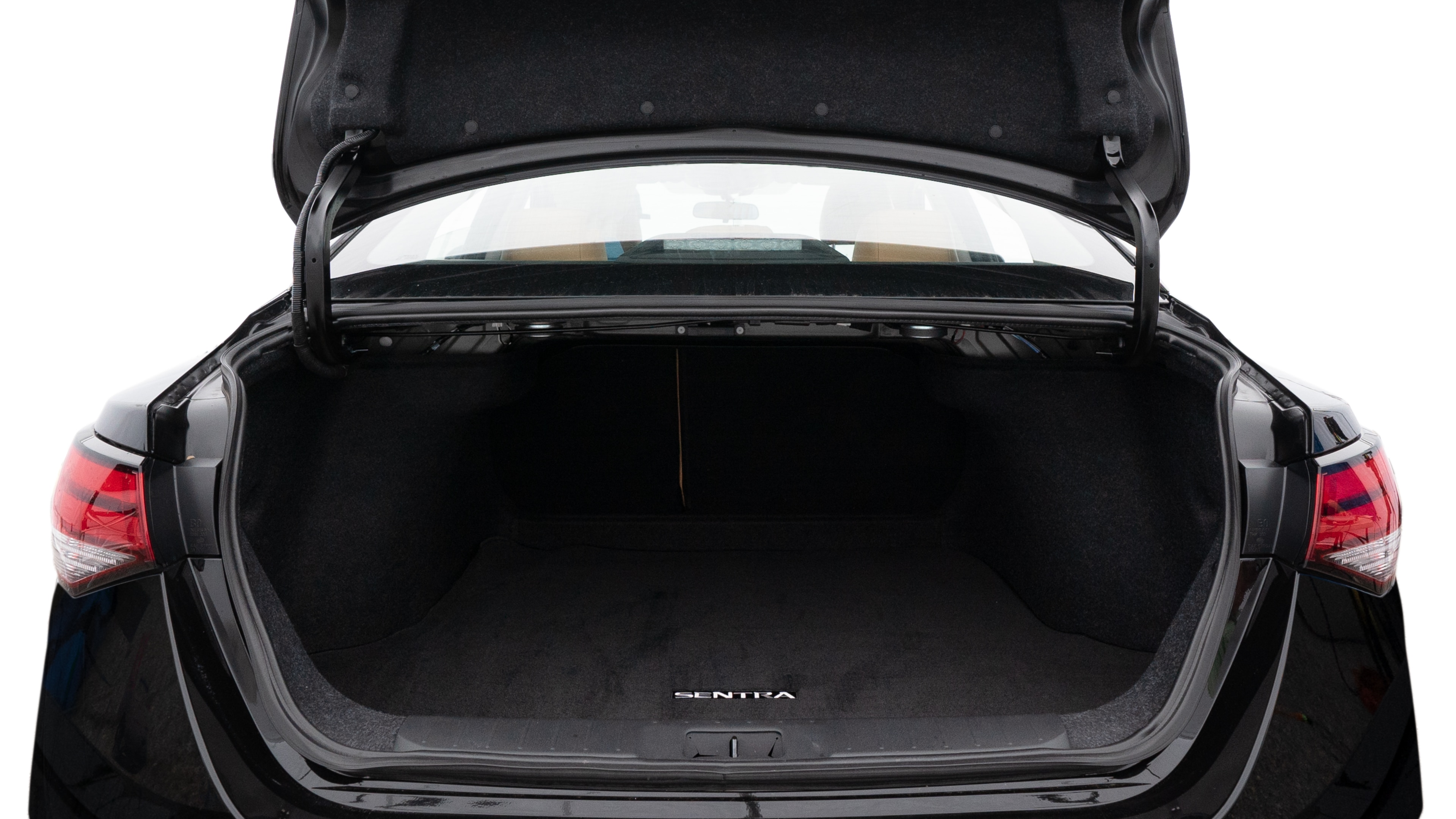 The trunk lid is open, showing full view of the trunk space. Two medium and two small suitcases are placed inside.