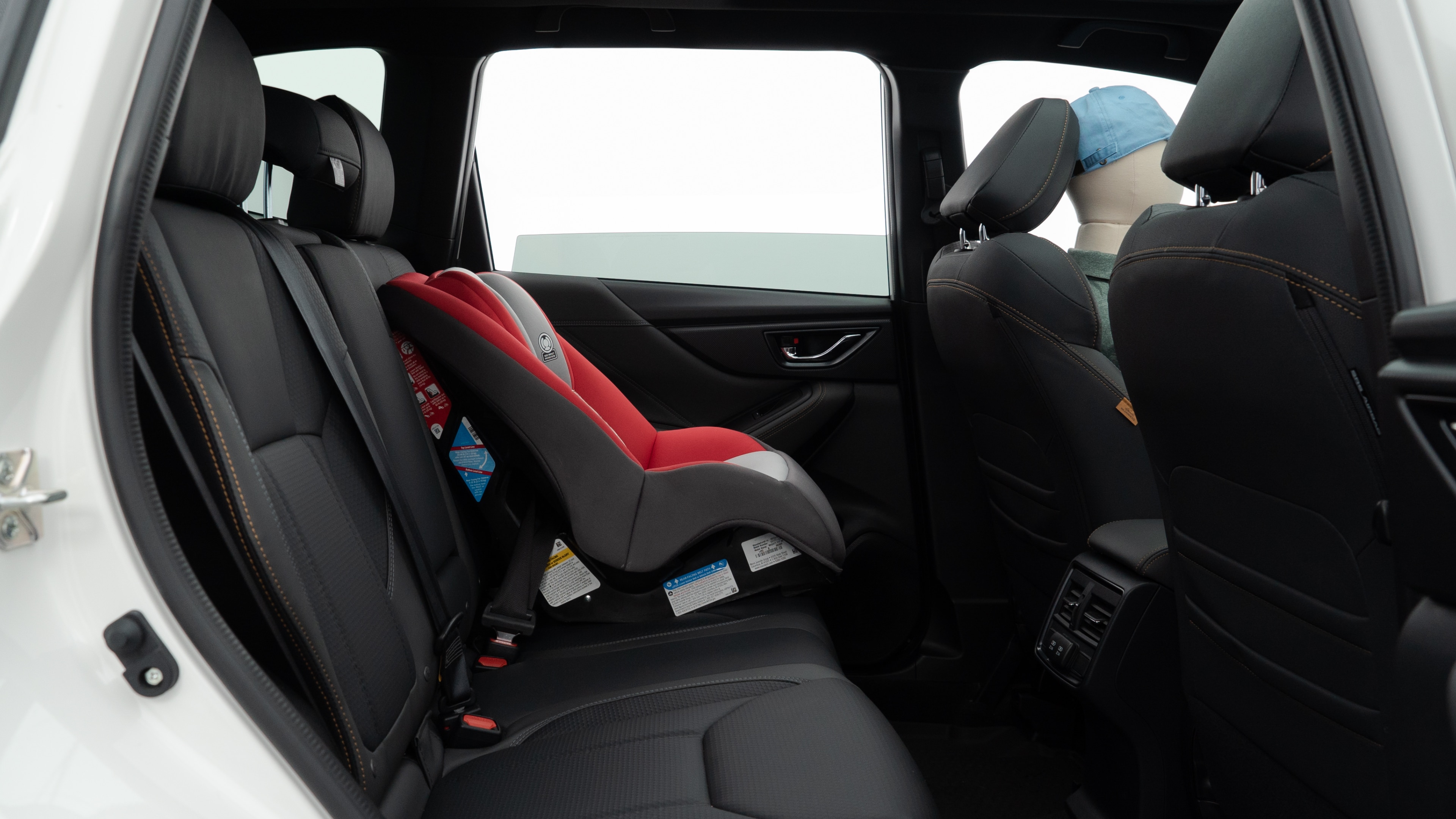A series of second-row backseat photos is shown including one seating a baby seat and one seating a 6'1" mannequin.