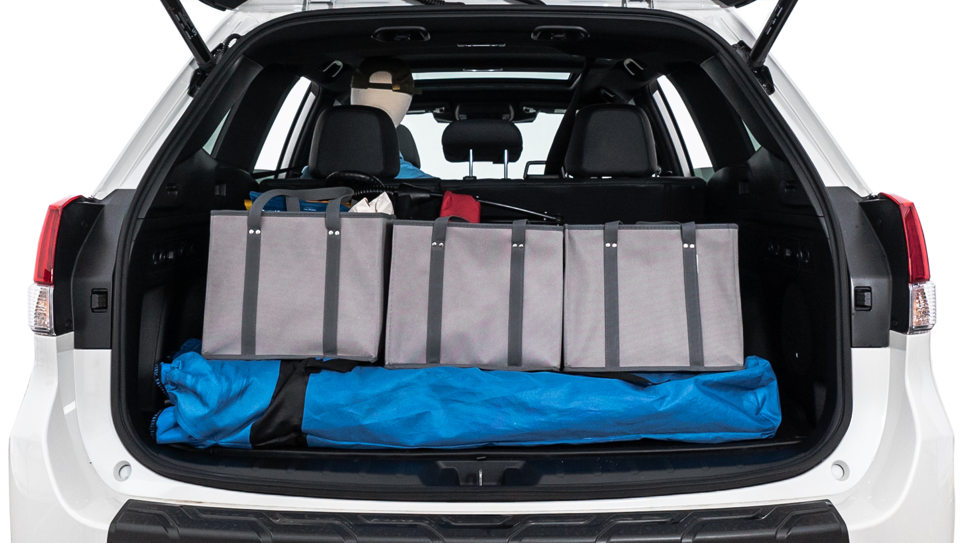 The trunk lid is open showing full view of the trunk. A baby stroller, three grocery carriers, two camping chairs in the carrying bag, and a set of golf clubs are placed inside.