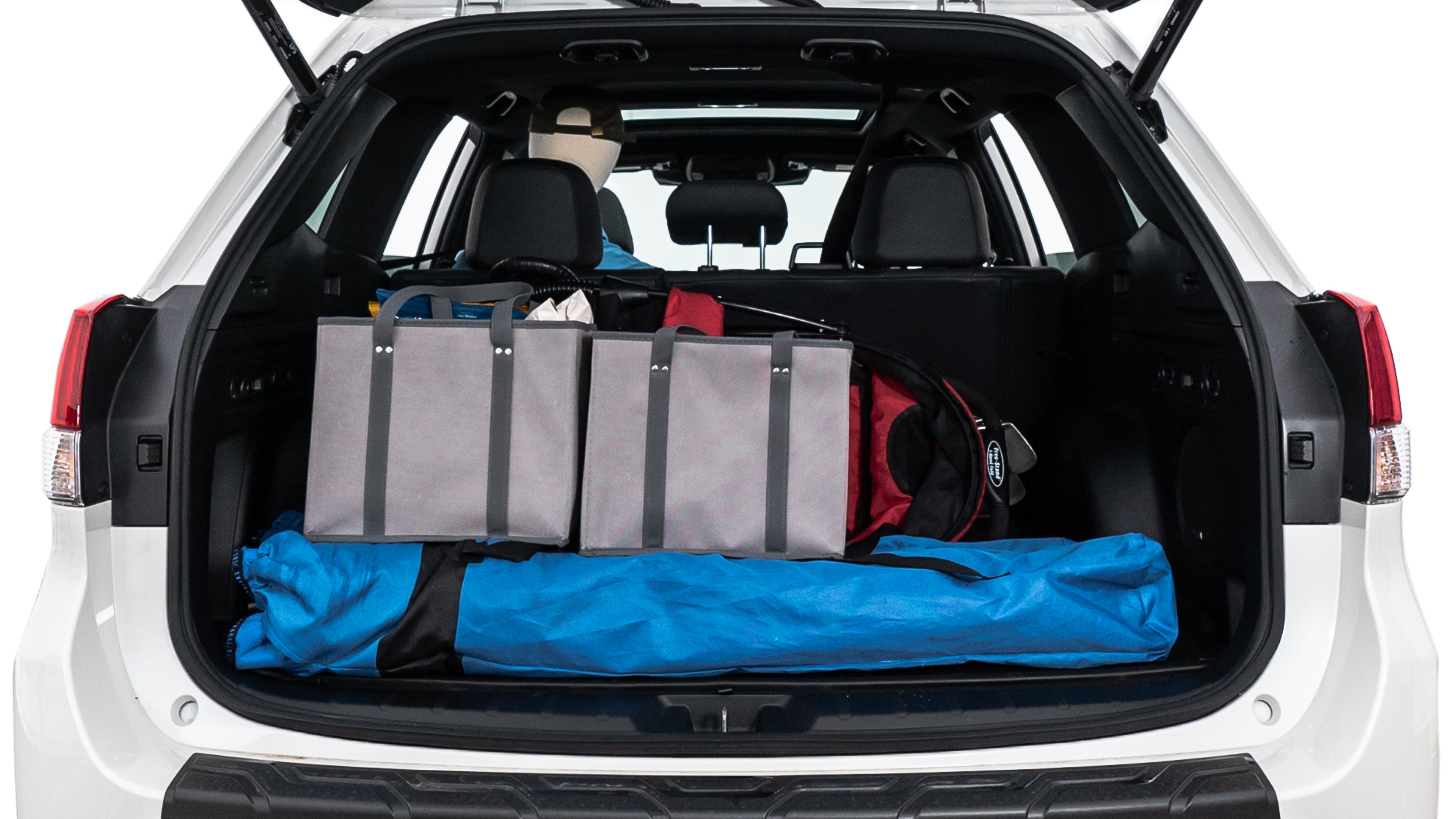 The trunk lid is open showing full view of the trunk. A baby stroller, three grocery carriers, two camping chairs in the carrying bag, and a set of golf clubs are placed inside.