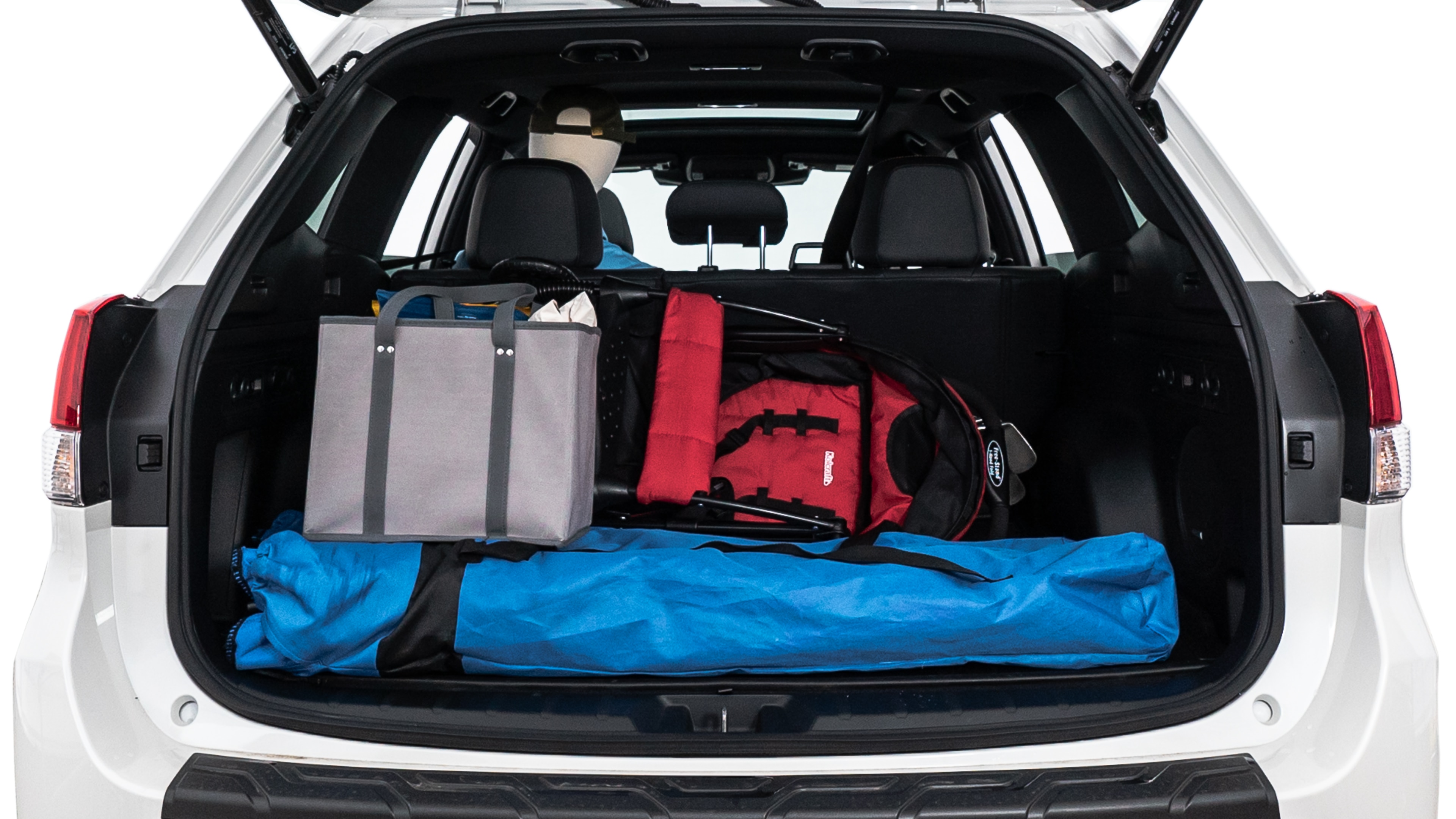 The trunk lid is open showing full view of the trunk. A baby stroller, three grocery carriers, two camping chairs in the carrying bag, and a set of golf clubs are placed inside.
