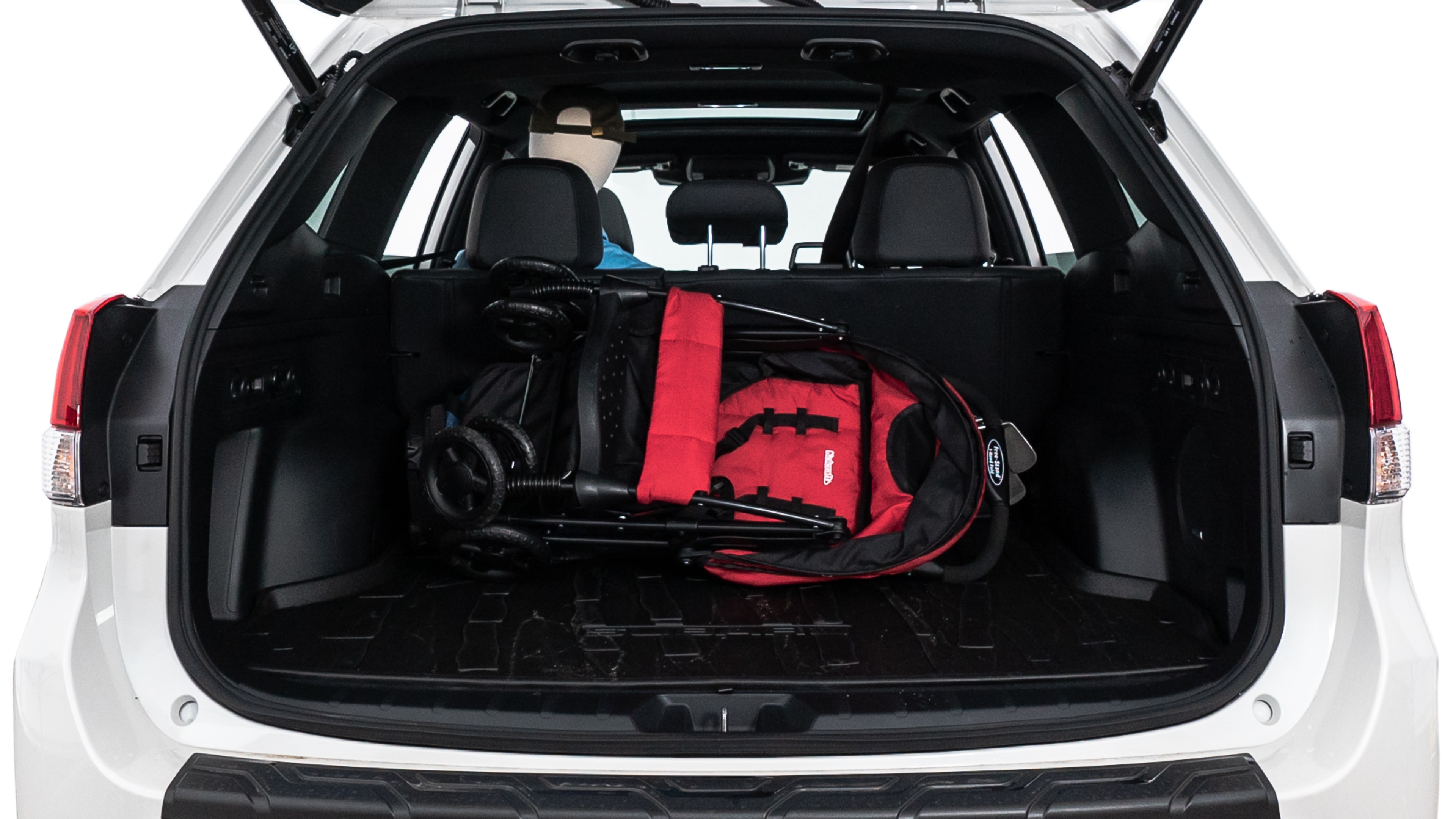 The trunk lid is open showing full view of the trunk. A baby stroller, three grocery carriers, two camping chairs in the carrying bag, and a set of golf clubs are placed inside.