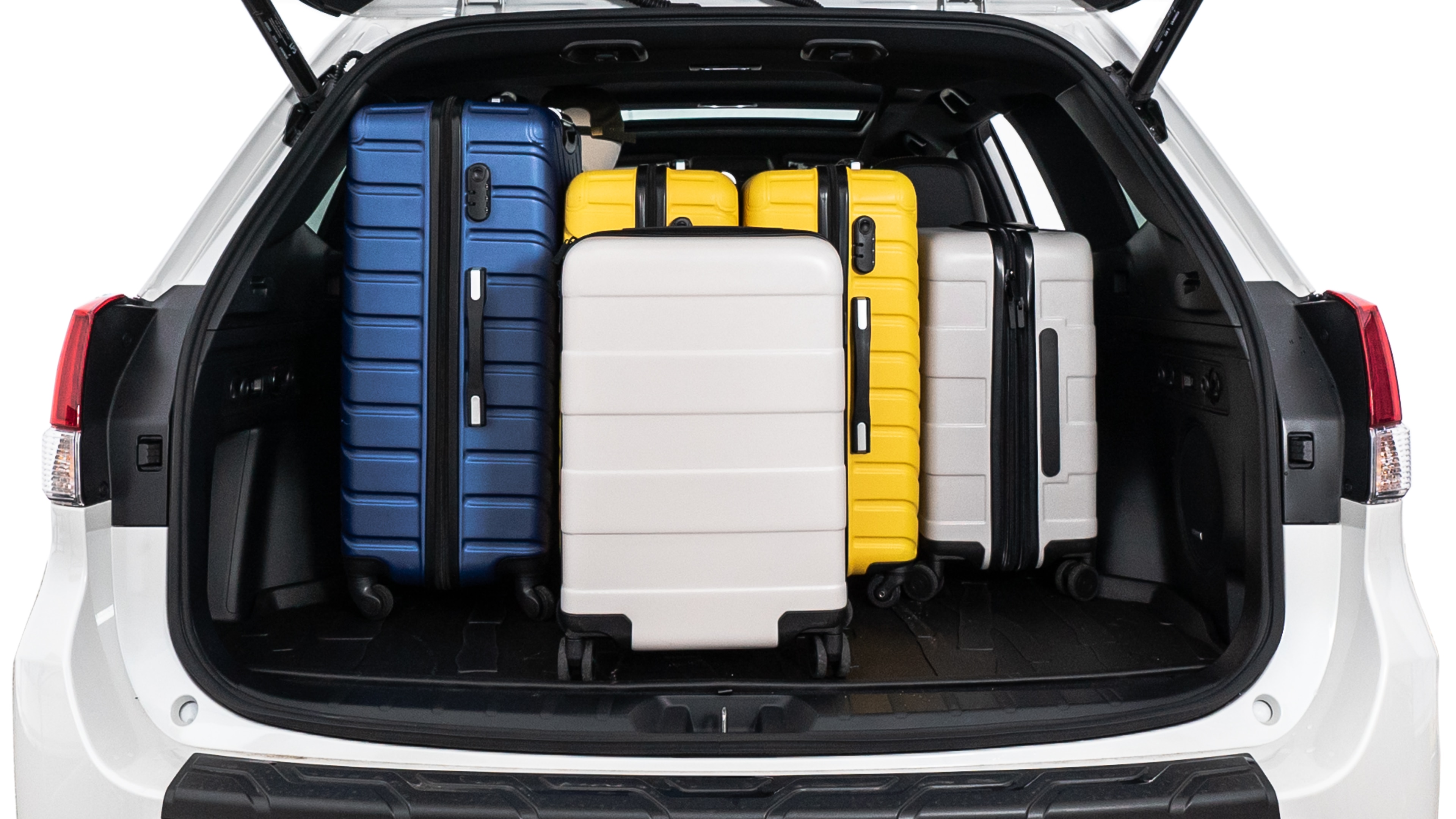 The trunk lid is open, showing full view of the trunk space. One large suitcase, two medium suitcases, and two small suitcases are placed inside.